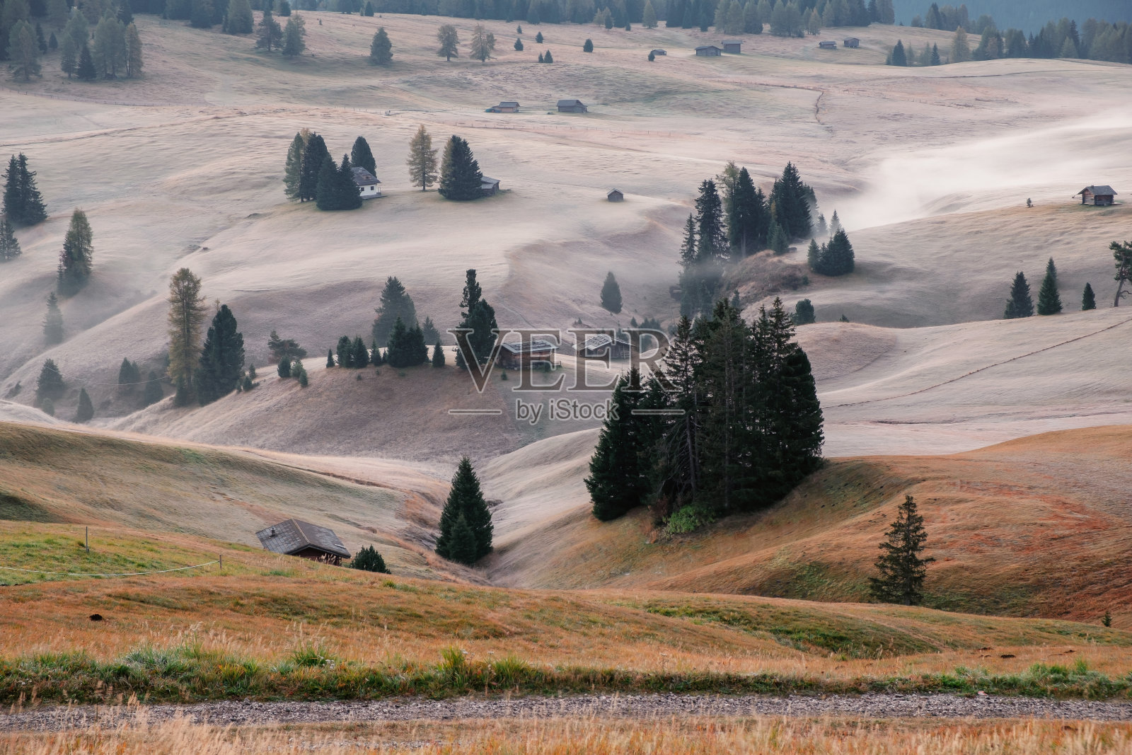 Alpe di Siusi (Seiser Alm)高山草甸,美丽的雾蒙蒙的日出在背景与萨索伦戈和Langkofel山脉和塞塞达山,南蒂洛尔照片摄影图片