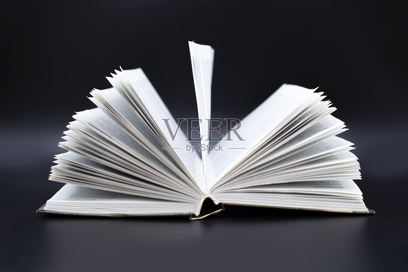 一本翻开的黑色背景的旧书。教育与发展的理念照片摄影图片