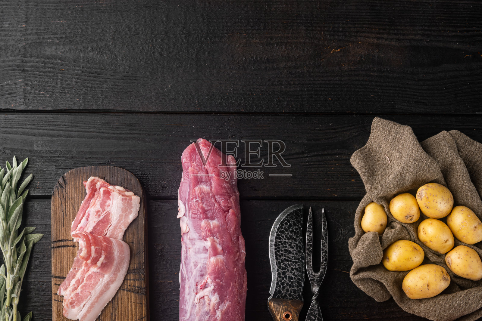 生猪肉和土豆泥的gratin原料,在黑色木桌背景,俯视图平铺,有copyspace和文本空间照片摄影图片