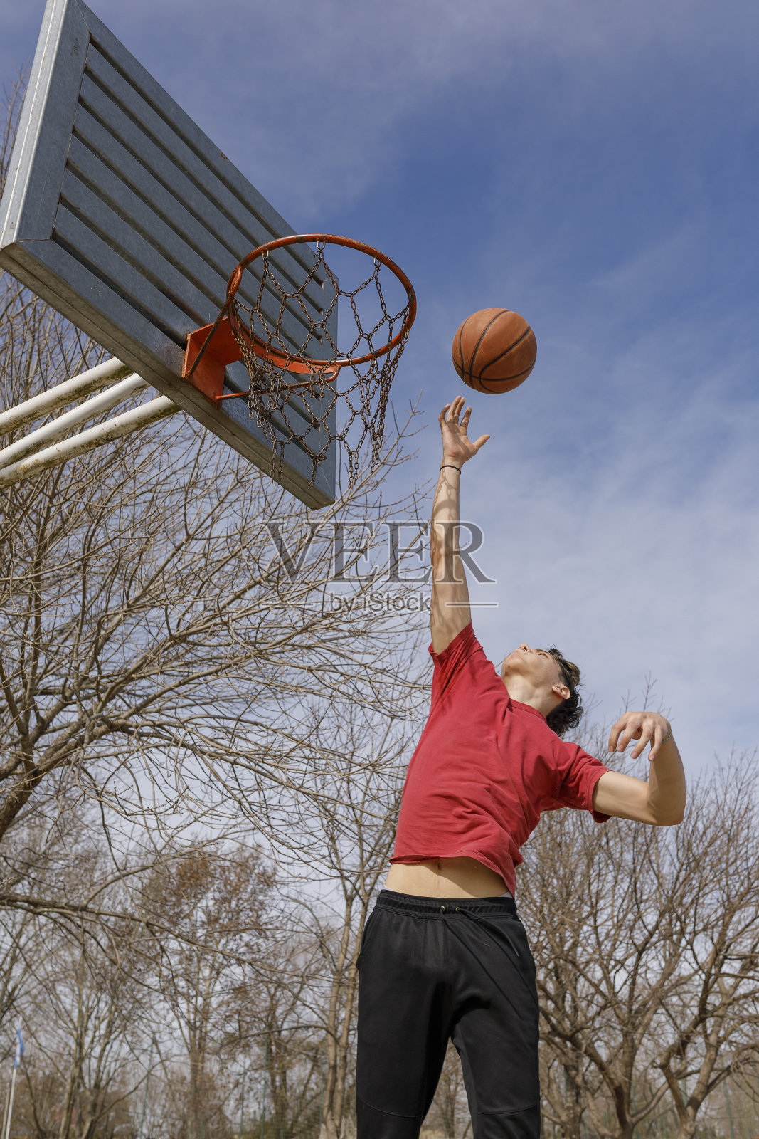 年轻的运动员在户外公园的篮球场上训练。照片摄影图片