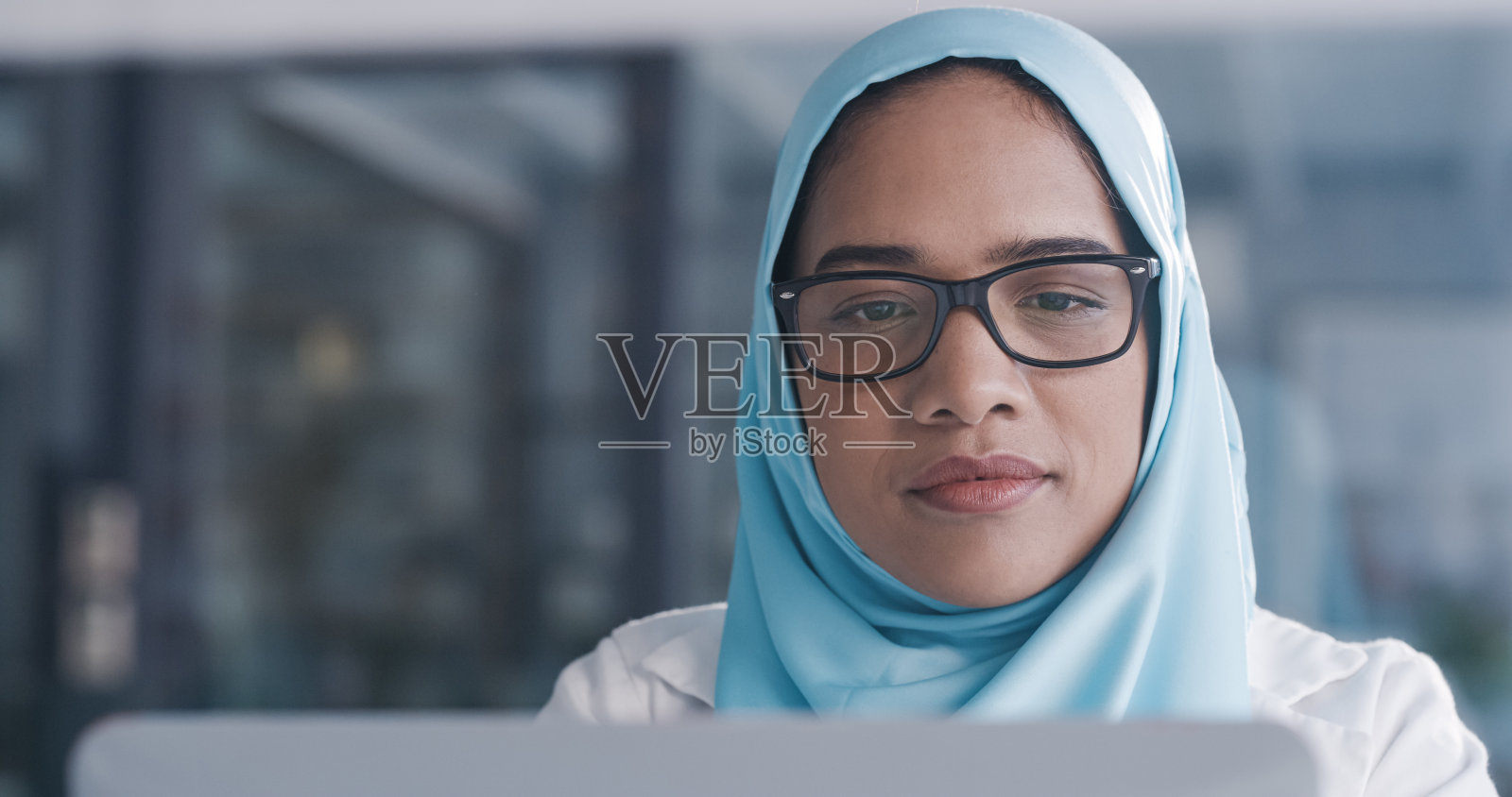 一名年轻女医生在办公室使用笔记本电脑照片摄影图片