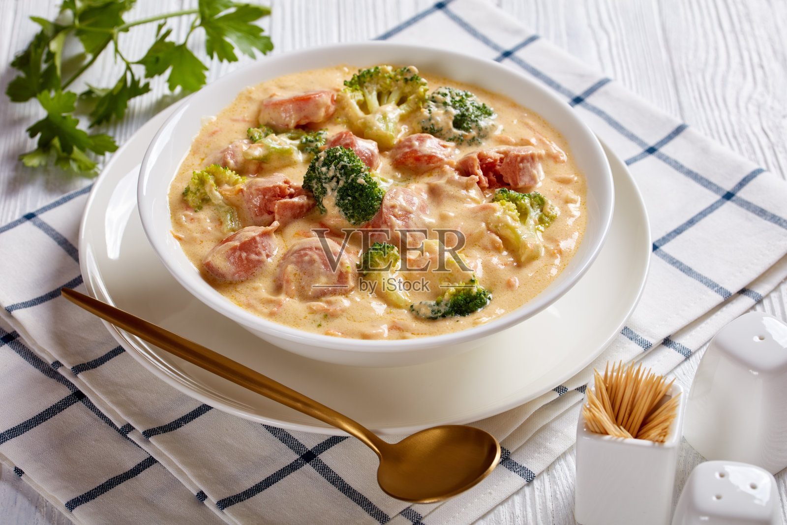 丰盛的西兰花切达奶酪香肠汤放在木桌上的白碗里,从上面俯瞰照片摄影图片