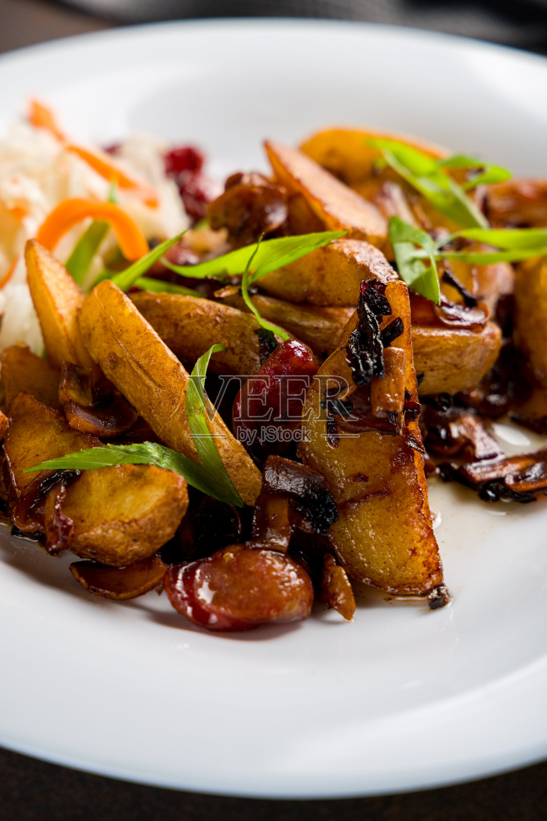 把炸土豆和切好的香肠放在白色盘子里,收好照片摄影图片