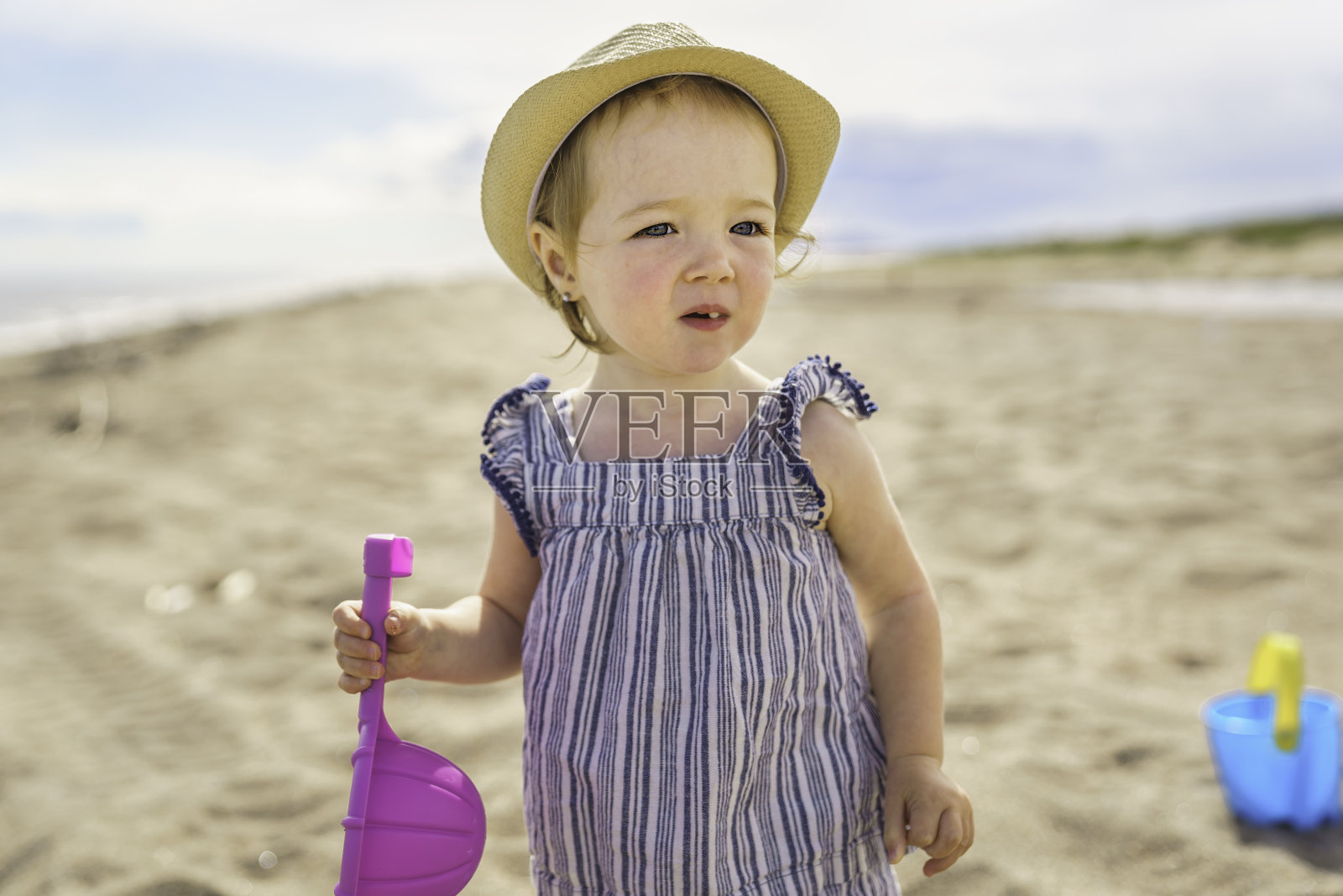 可爱的小女孩在沙滩上玩她的玩具照片摄影图片