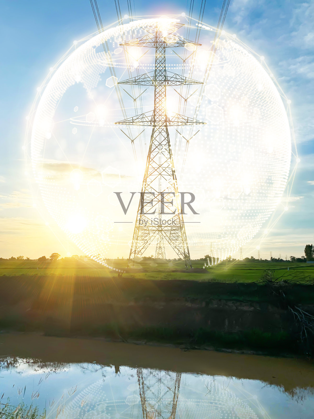 傍晚时分,在小稻田上安装了大型高压电杆。用于高压电缆基础的钢结构,设计为高度安全照片摄影图片