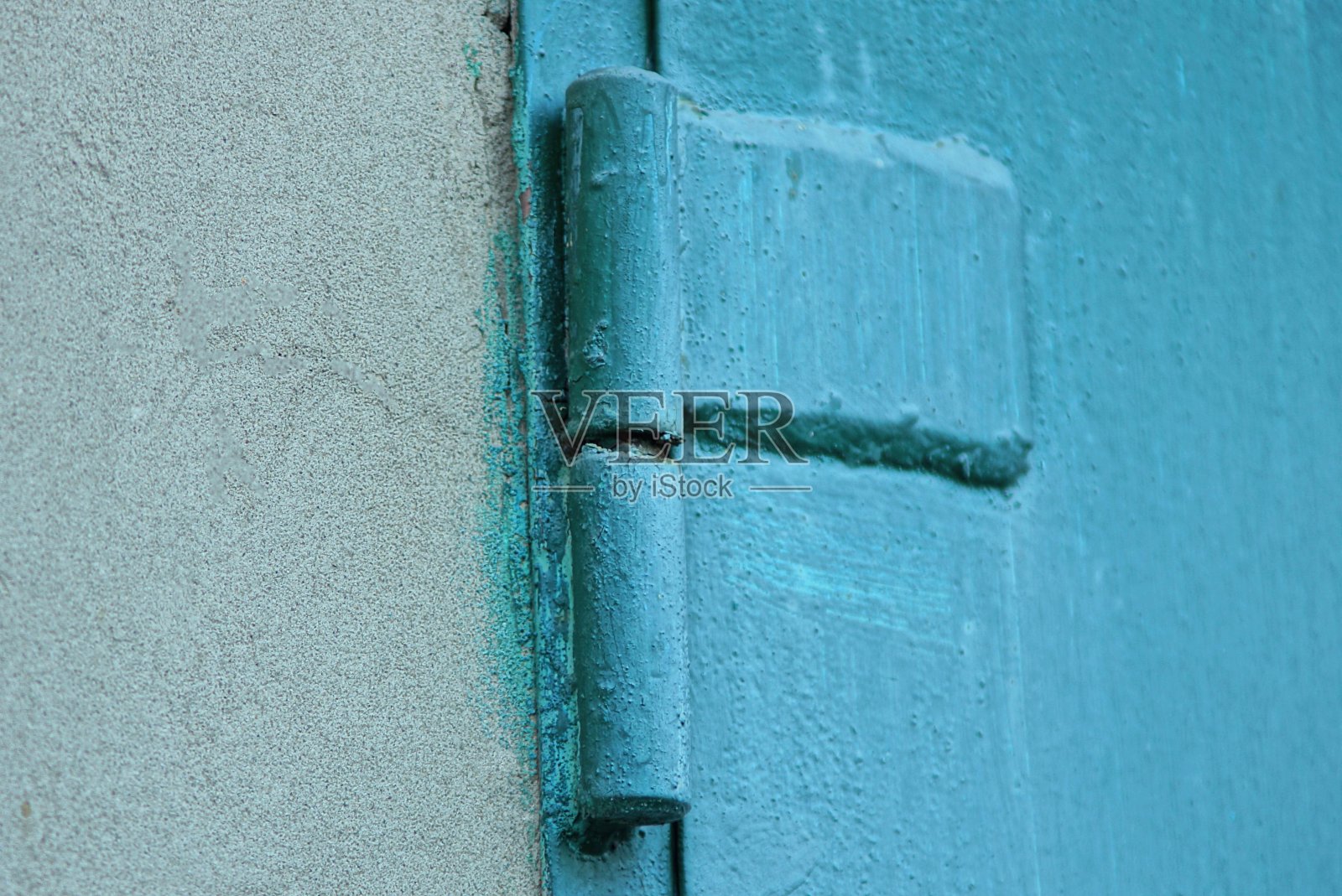铁门铰接在灰色的水泥墙上照片摄影图片