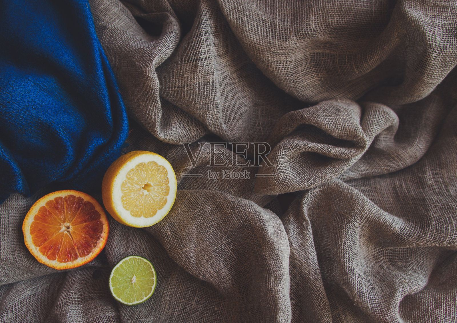 橙色,黄色,柠檬,绿色,酸橙和香料香草在棕色粗糙的粗布织物照片。A4 A5国际纸幻灯片海报卡角元素与免费的空白复制空间为文本照片摄影图片