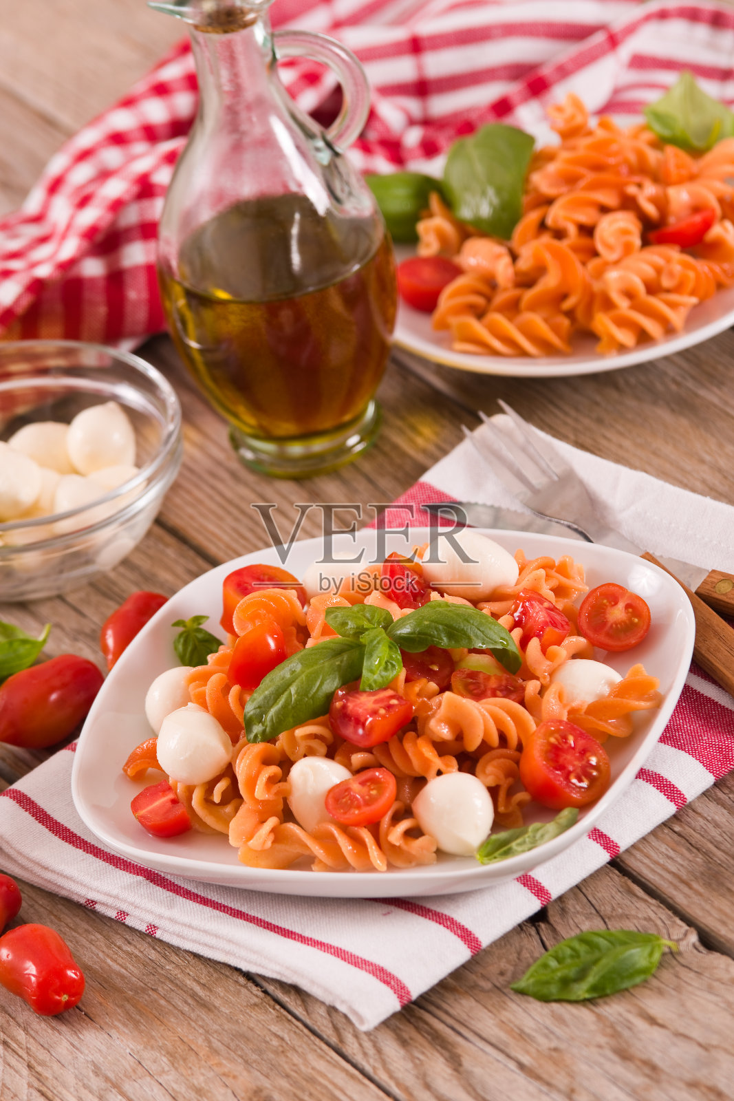 意大利通心粉配樱桃番茄和马苏里拉奶酪。照片摄影图片