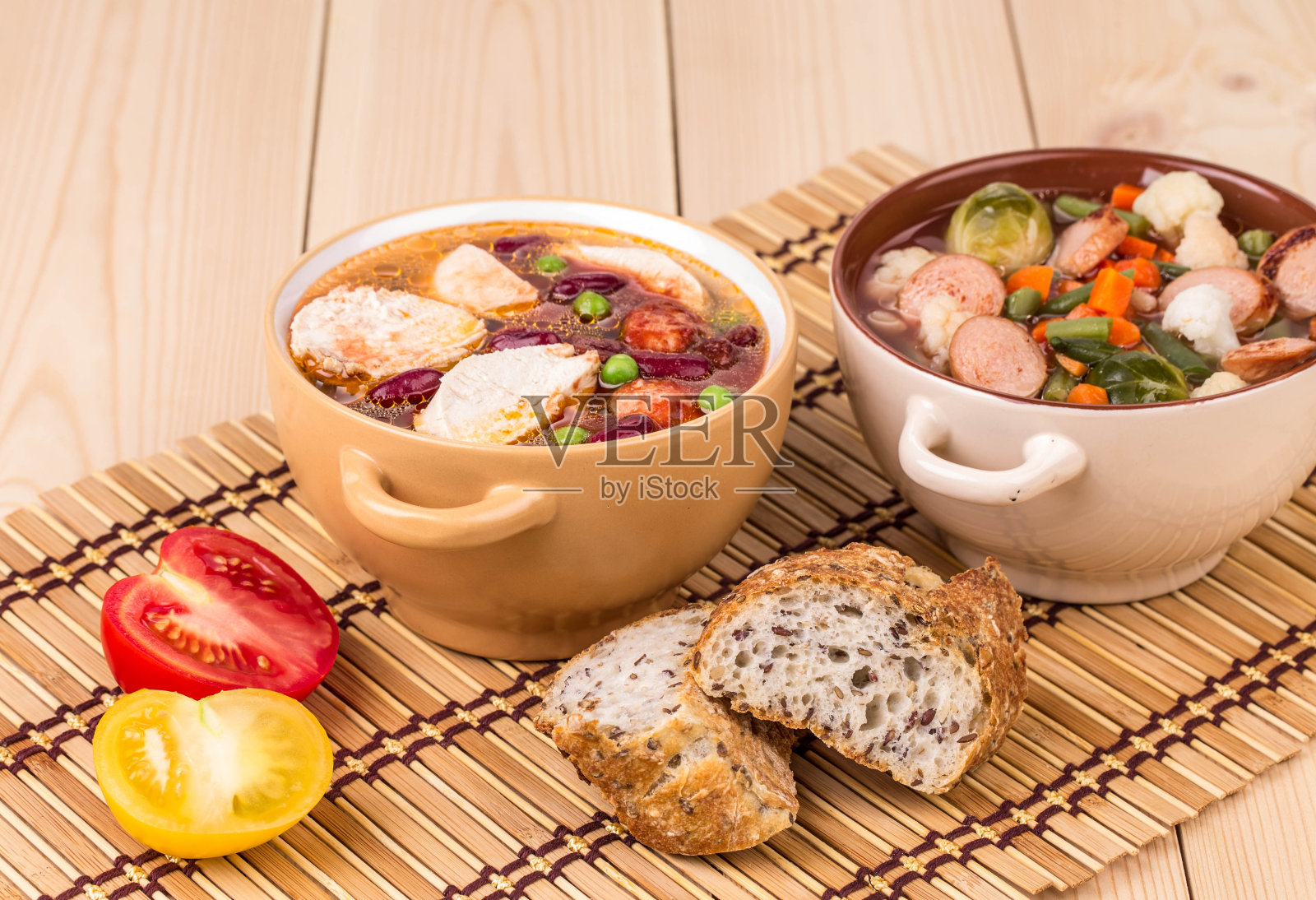 两碗有新鲜蔬菜和香肠的汤。照片摄影图片