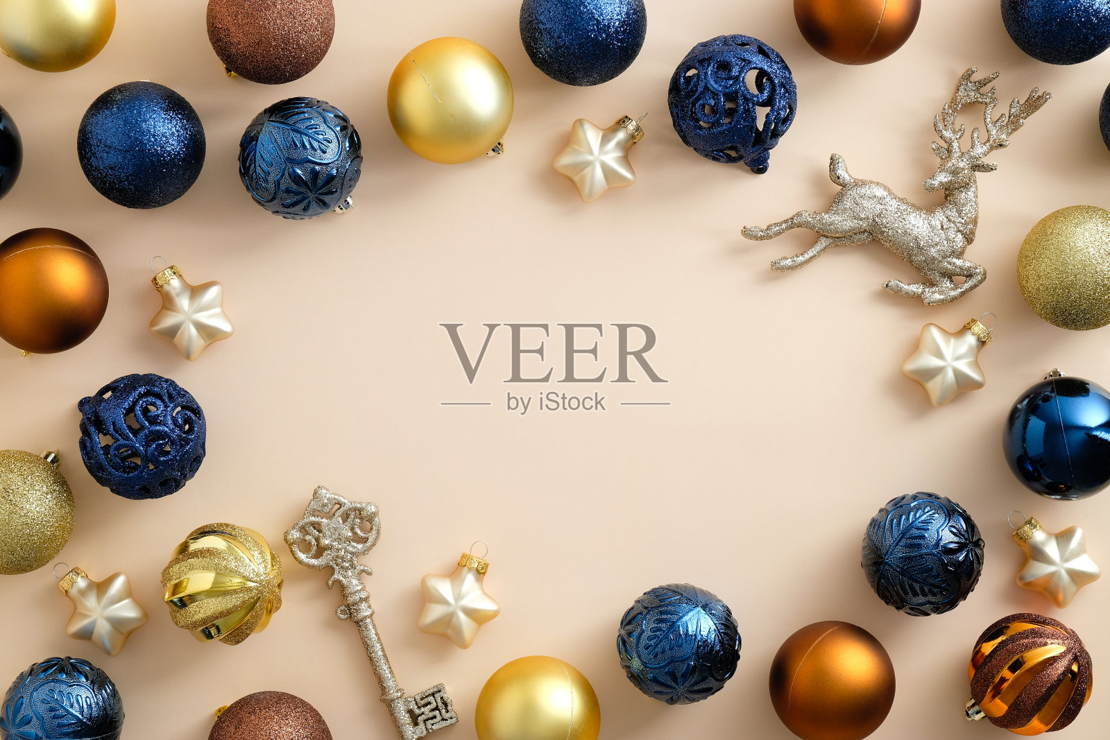 现代圣诞组成。框架由蓝色,青铜和黄金小玩意,星星,钥匙,鹿在柔和的米色背景。圣诞贺卡模板,横幅模型照片摄影图片