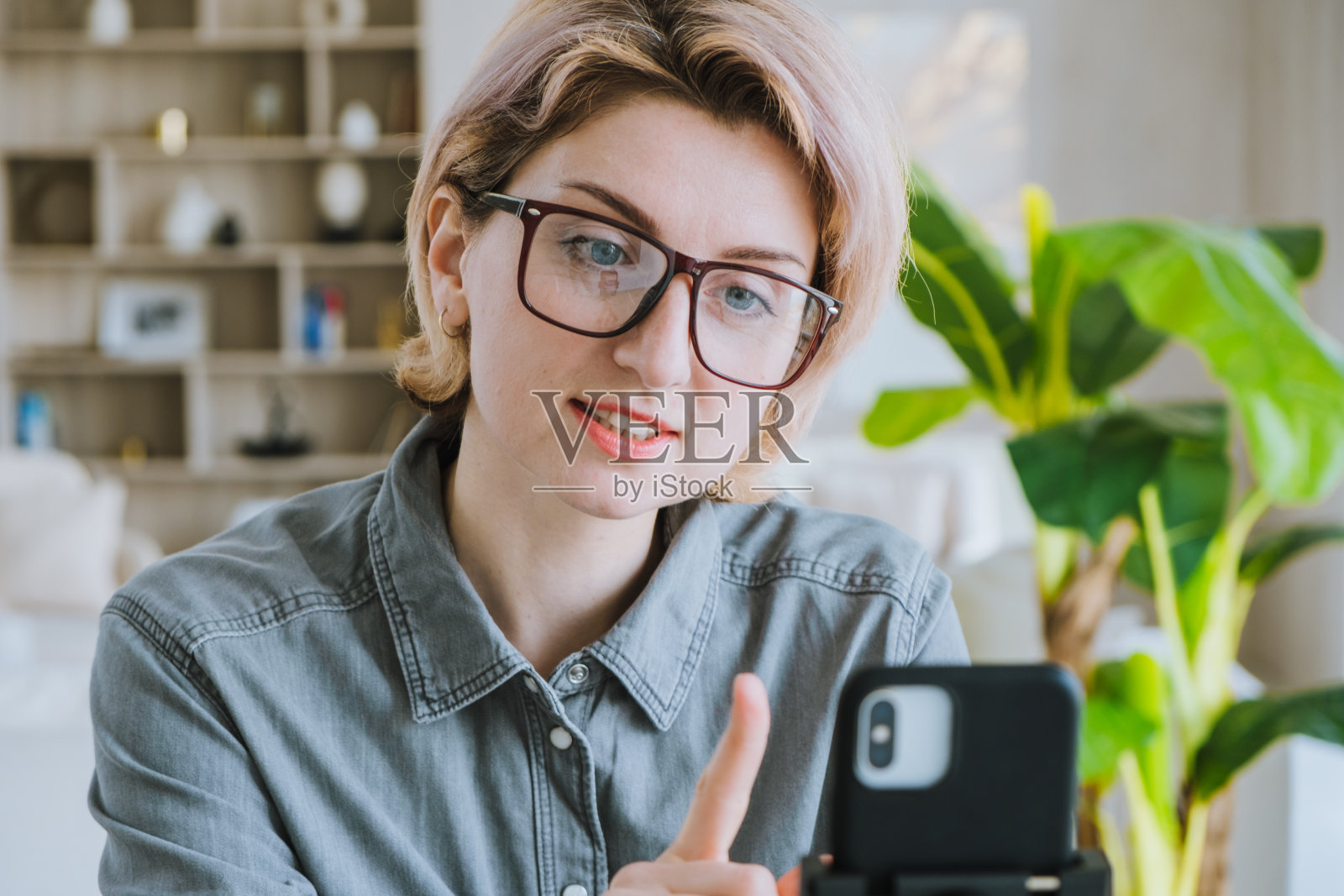 在一间舒适的办公室里,一位女博主在电话前发表演讲照片摄影图片