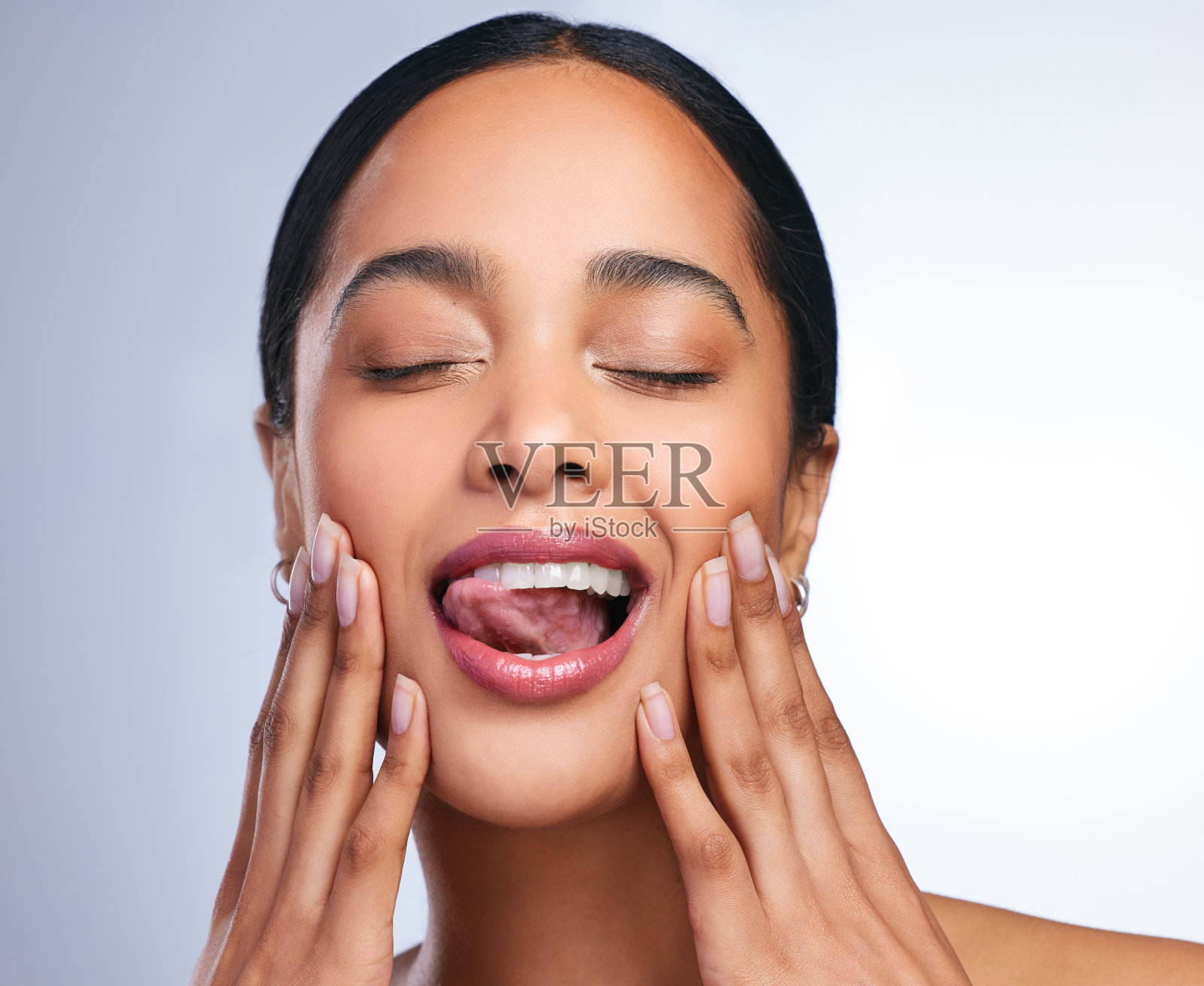 一个美丽的年轻女子在灰色的背景下摆姿势照片摄影图片