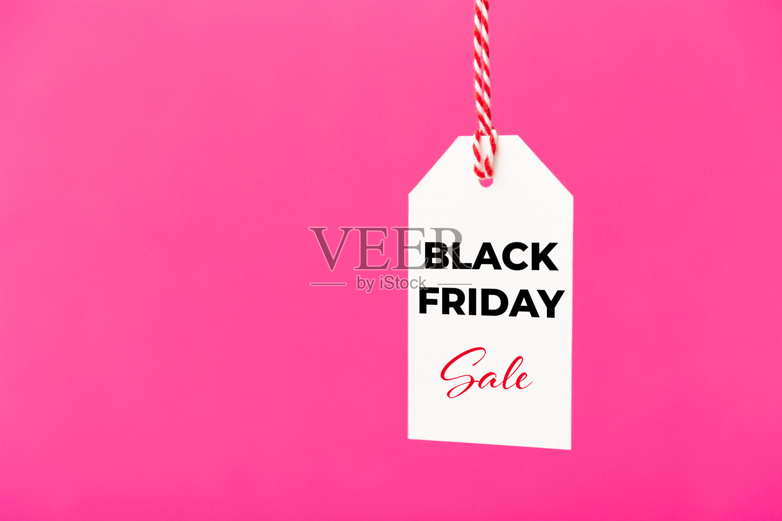 黑色星期五销售白色价格标签孤立在粉红色的背景。购物、促销、折扣的概念照片摄影图片