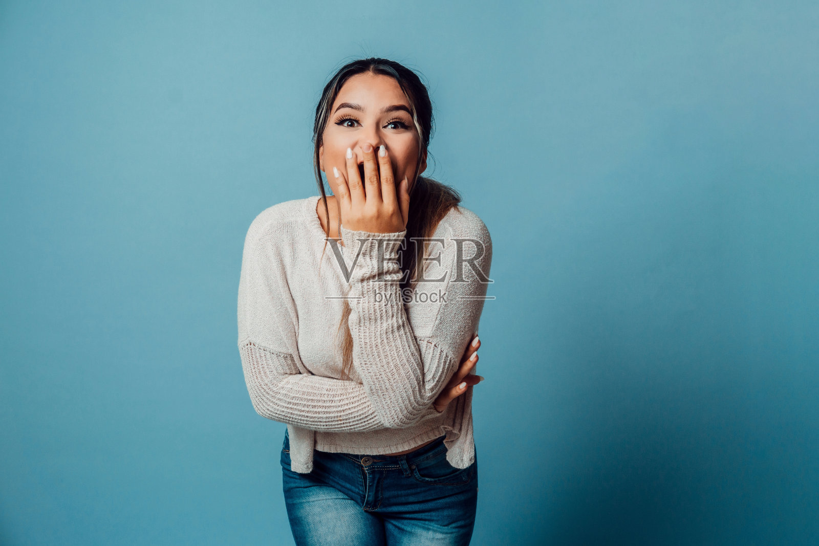 女人惊讶地手牵着嘴,漂亮的卷发女孩指着右边照片摄影图片