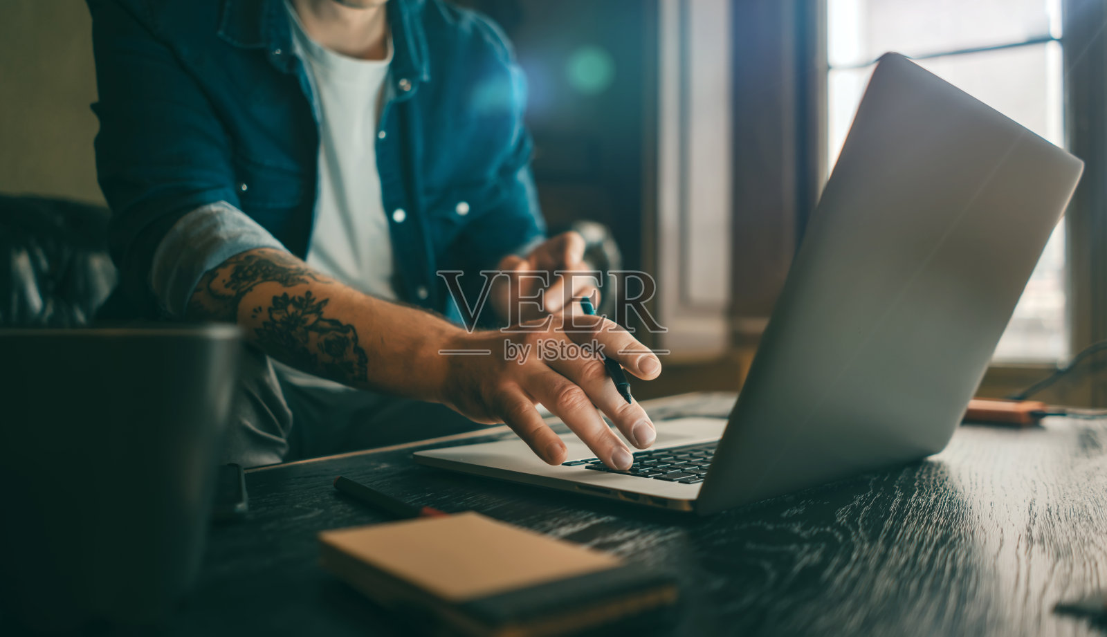 男性手持笔记本电脑的特写镜头。男人在家远程工作。自由职业者的工作照片摄影图片