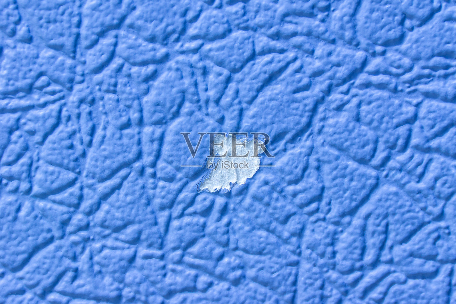 新粉刷的蓝色墙纸上的油漆被撕下来了照片摄影图片