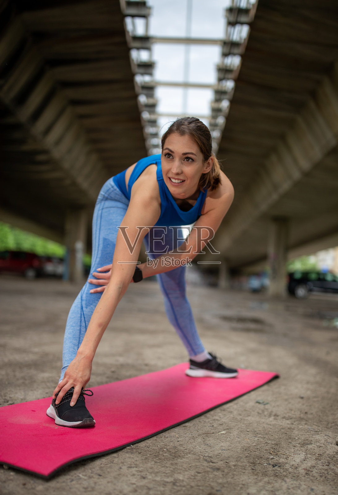 女孩在户外运动垫上伸展身体照片摄影图片