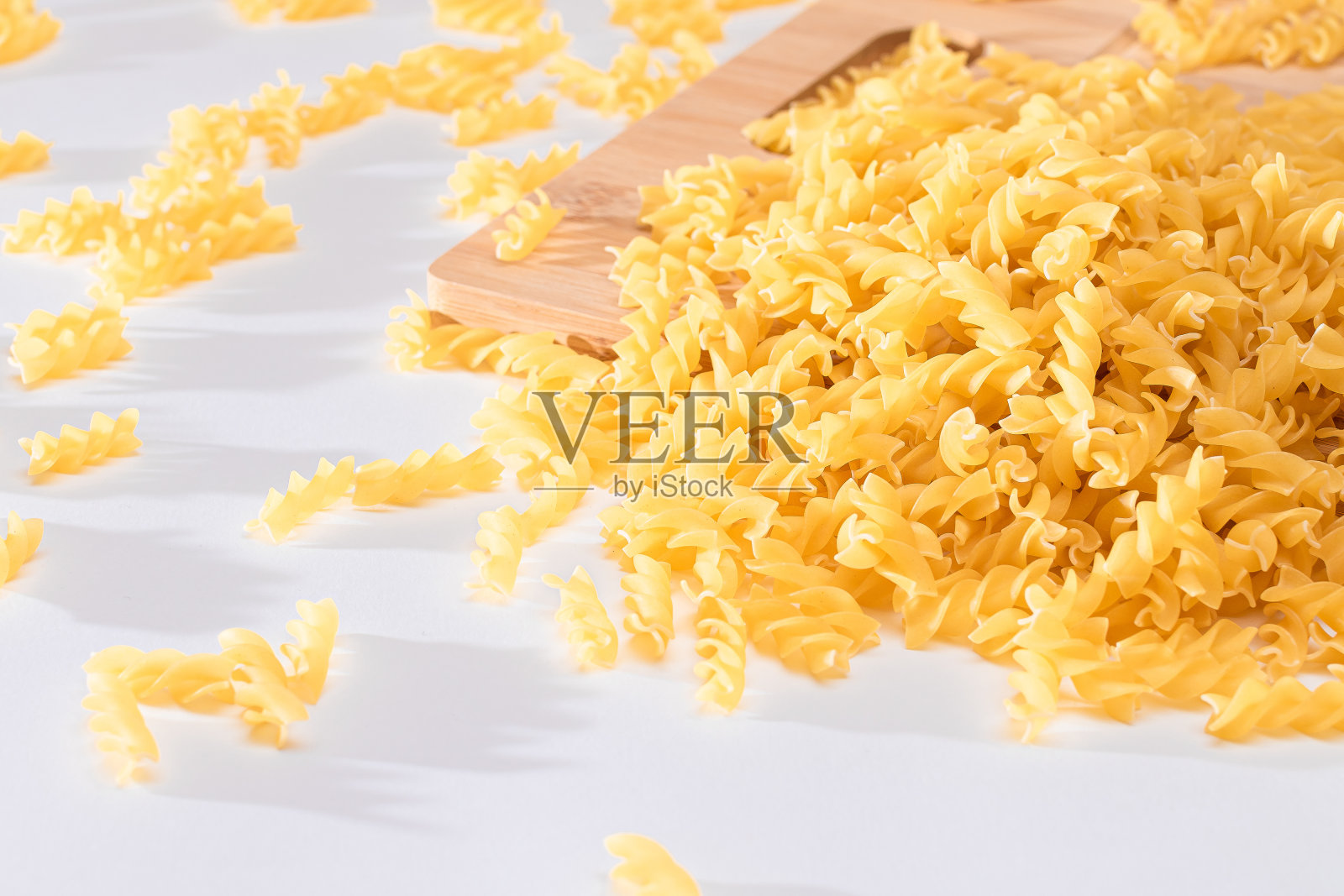 未煮熟的意大利通心粉散落在木板上照片摄影图片