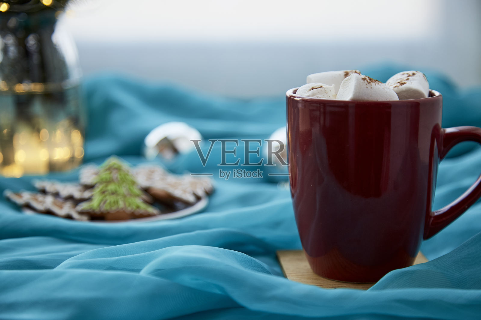 一杯热饮,配棉花糖和自制的圣诞饼干。快乐的假期背景上的蓝色织物。圣诞快乐,家庭舒适概念照片摄影图片