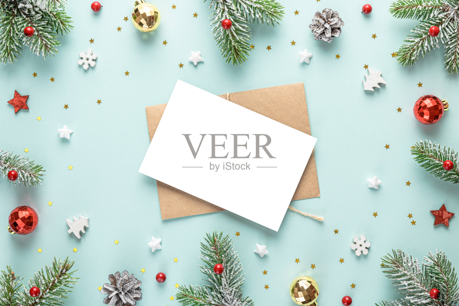 圣诞贺卡的框架由雪冷杉树,节日装饰在蓝色的背景。平的。模拟了照片摄影图片