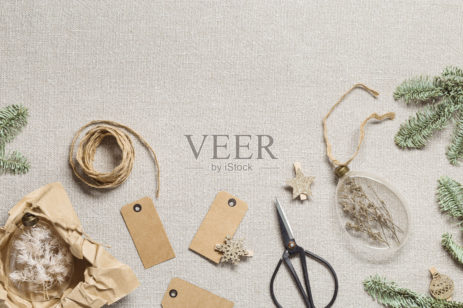 装着干花和草的玻璃小玩意。布袋桌布上的圣诞装饰品。带标签或工艺标签的新年节日礼物,室内装饰,DIY圣诞植物球照片摄影图片