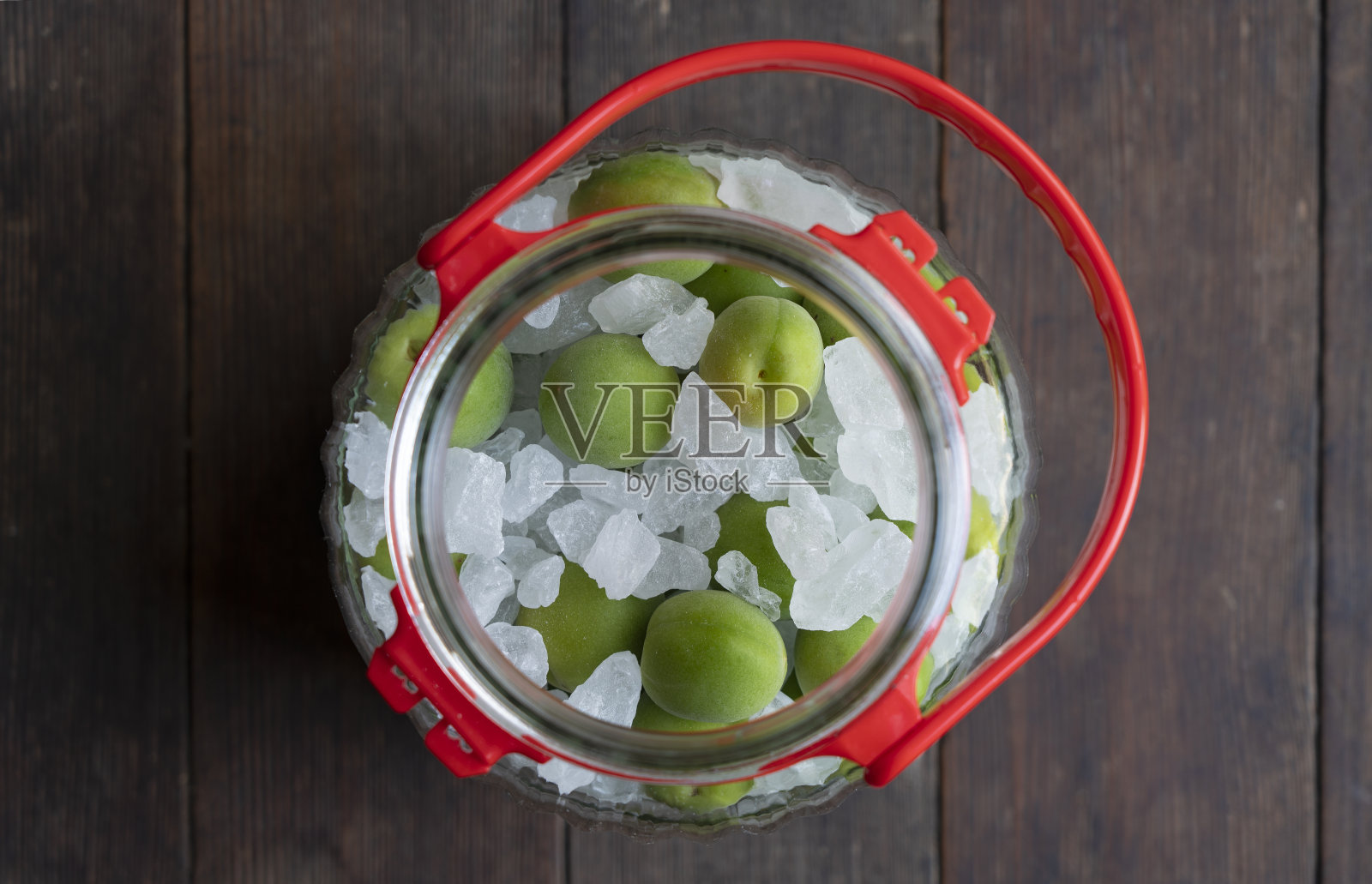 木制背景上的未成熟的红果和冰糖。照片摄影图片