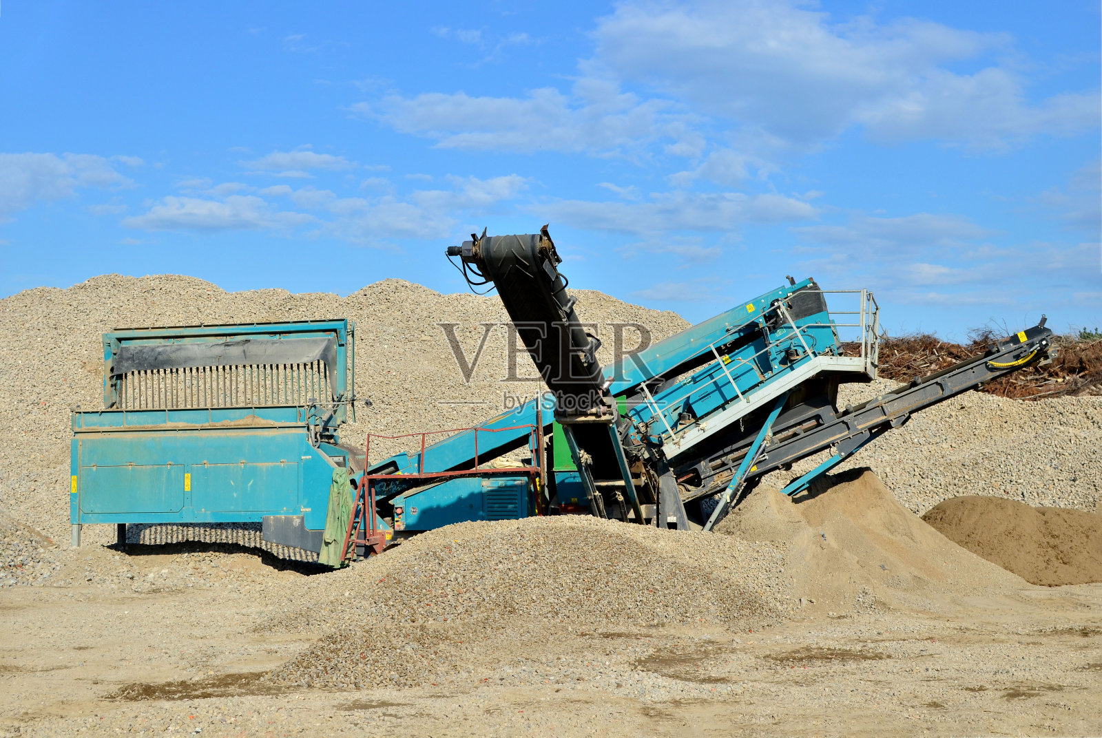 颚式破碎机用于垃圾填埋场上的石头破碎。回收拆除后的混凝土和建筑废物。照片摄影图片