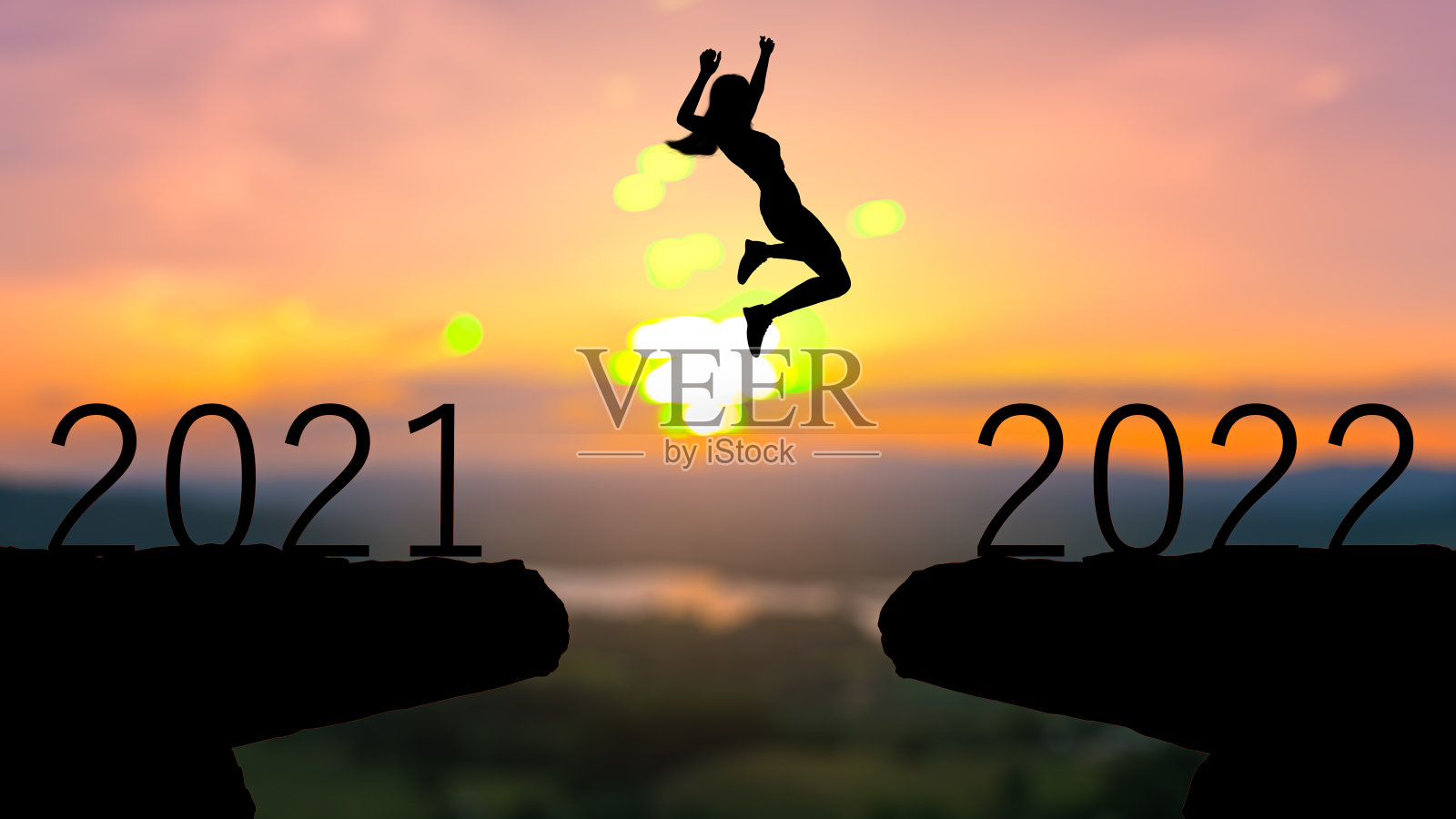 剪影人跳跃在2021年和2022年与日落背景,年2022概念照片摄影图片