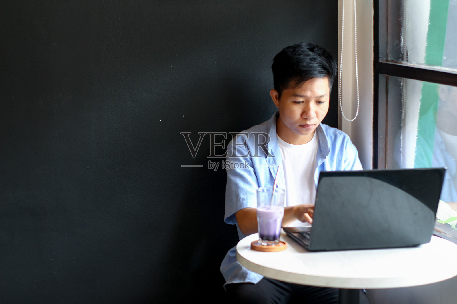 在咖啡馆用笔记本电脑工作的年轻人照片摄影图片