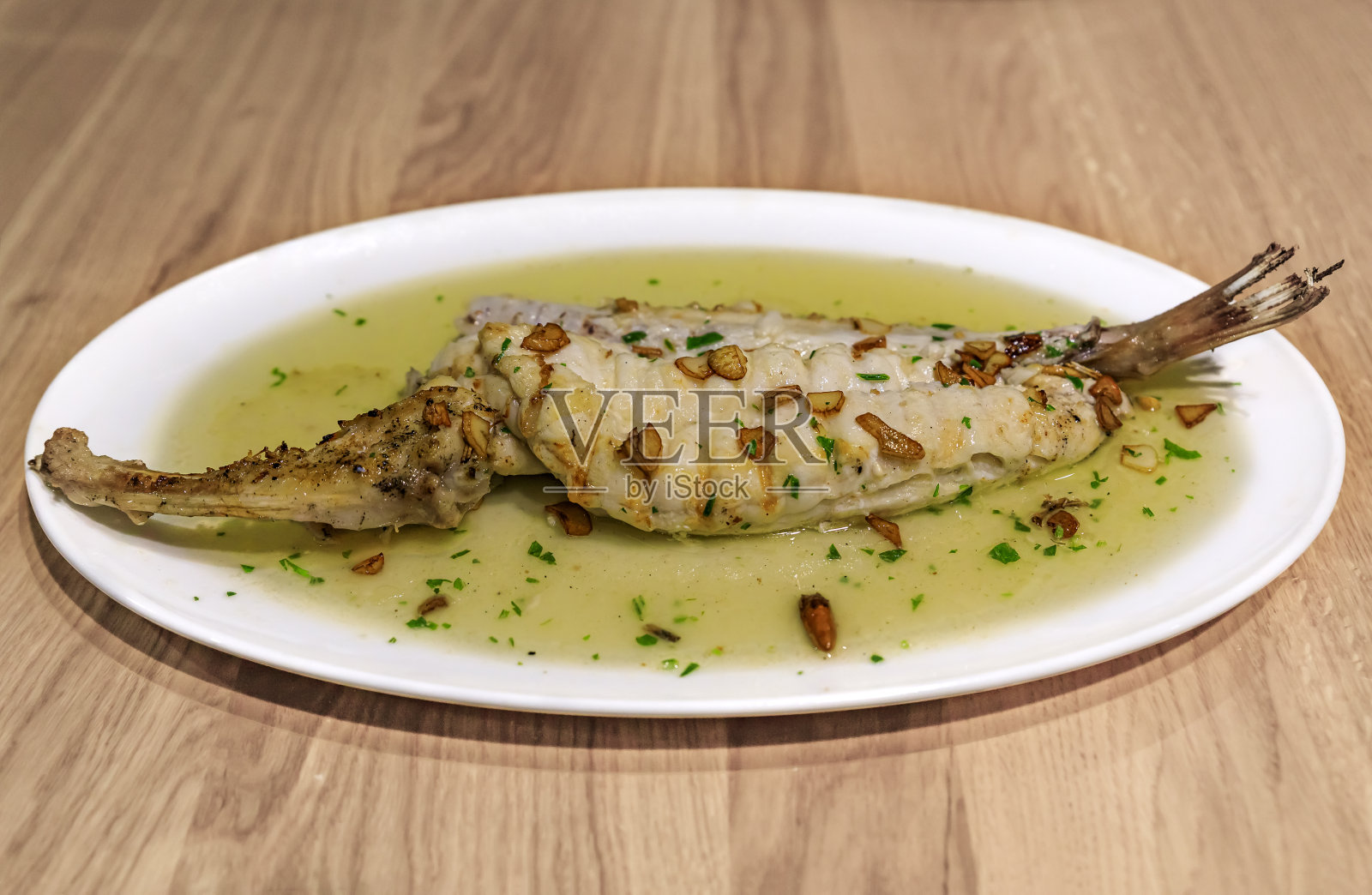 西班牙潘普洛纳一家餐馆里的传统巴斯克菜:鳕鱼配pil pil酱照片摄影图片