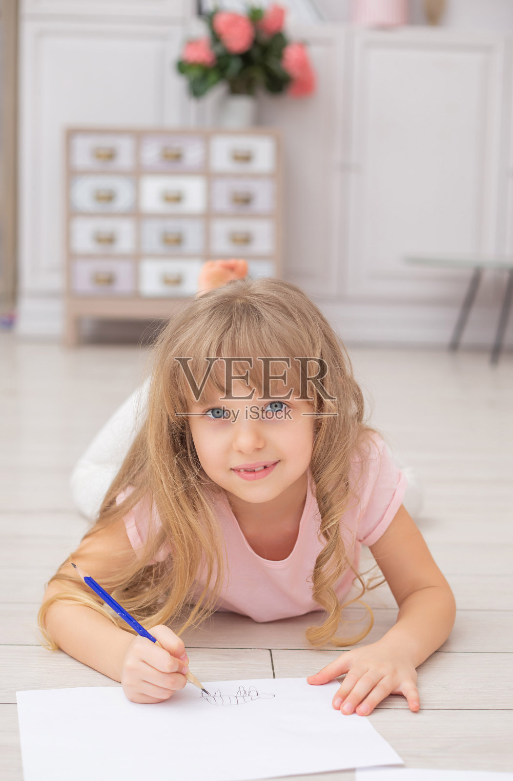 可爱的白人女孩画坐在客厅的地板上照片摄影图片