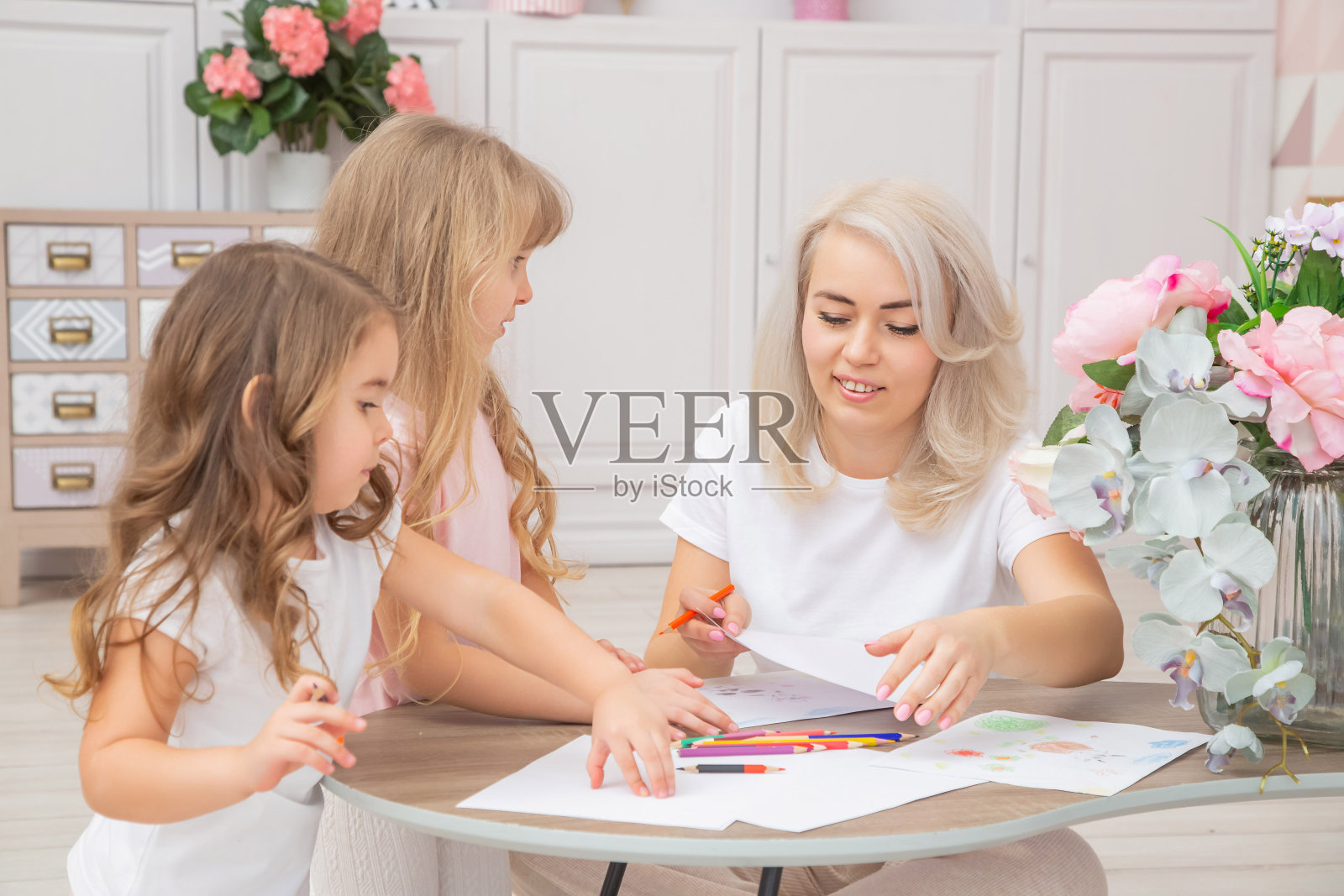 笑容满面的白人妈妈和两个女儿坐在地板上照片摄影图片