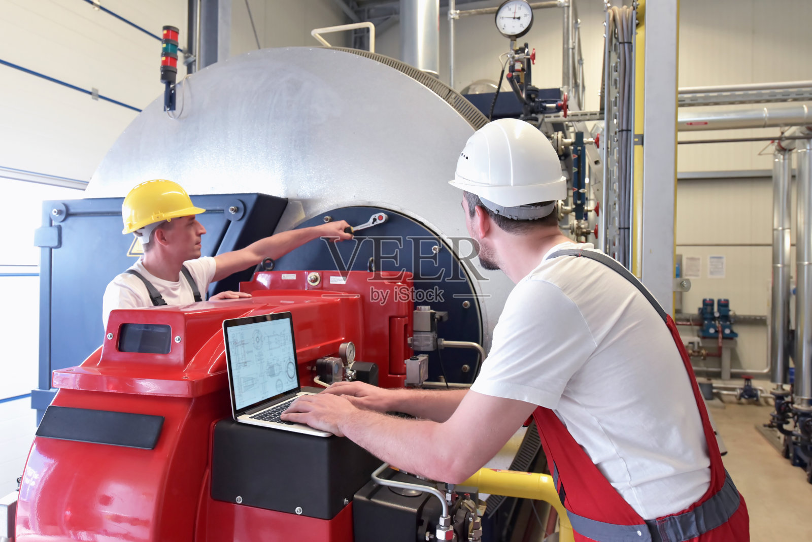 机械工在现代化工厂修理机器-专业和团队合作照片摄影图片