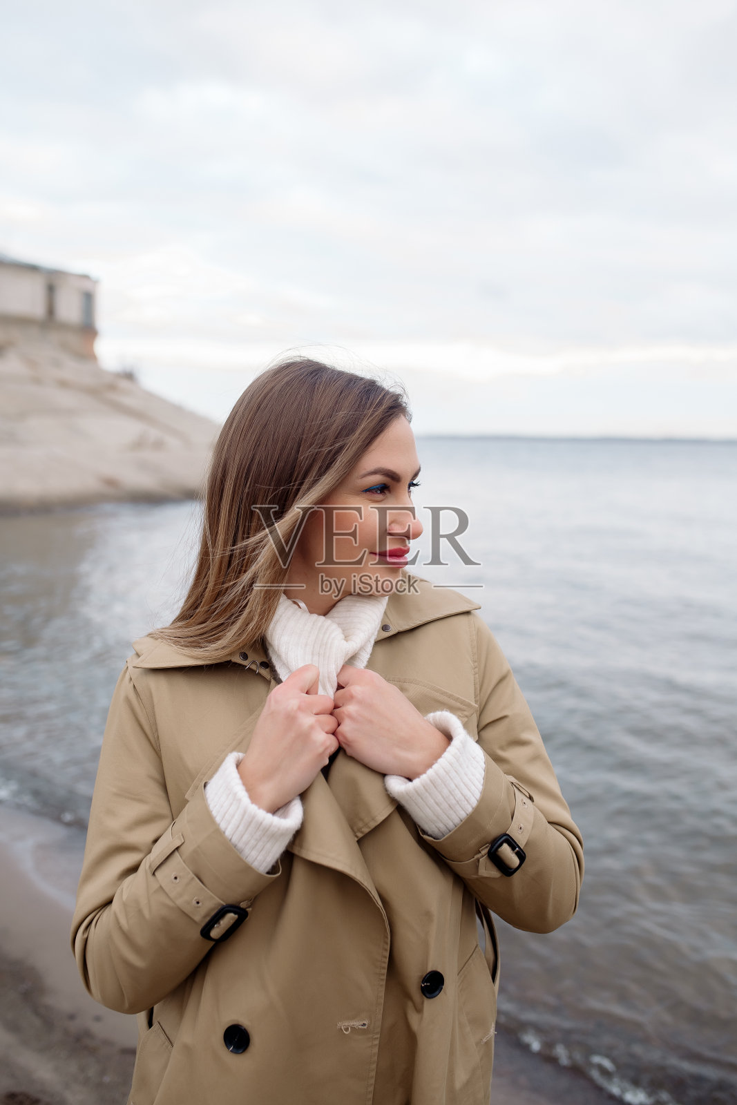 秋天,一个年轻的女人走在海滩上照片摄影图片
