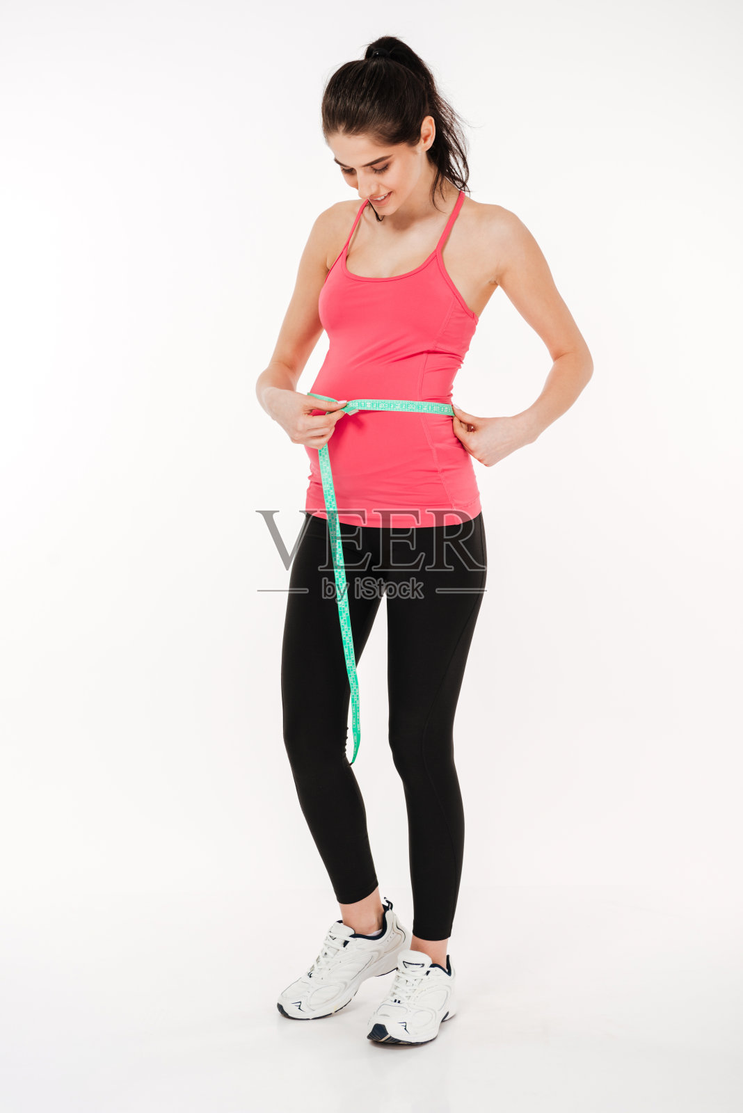 怀孕健身妇女的全身肖像测量她的肚子照片摄影图片