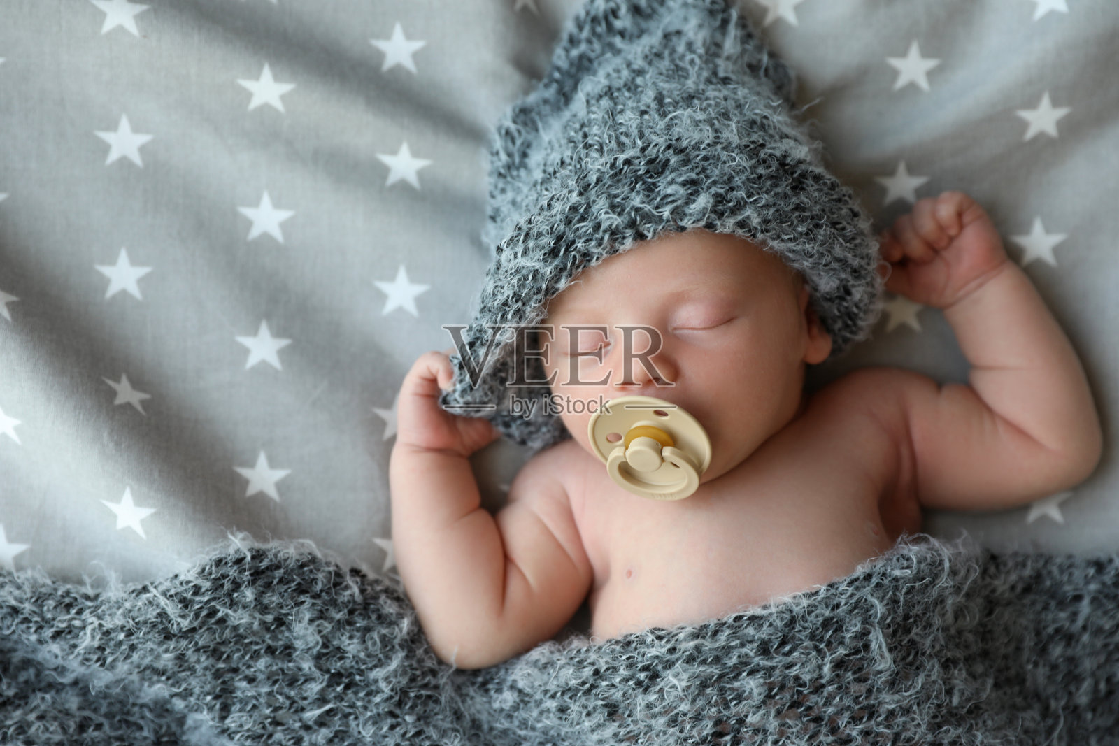 可爱的新生儿在温暖的帽子睡在床上,俯视图照片摄影图片