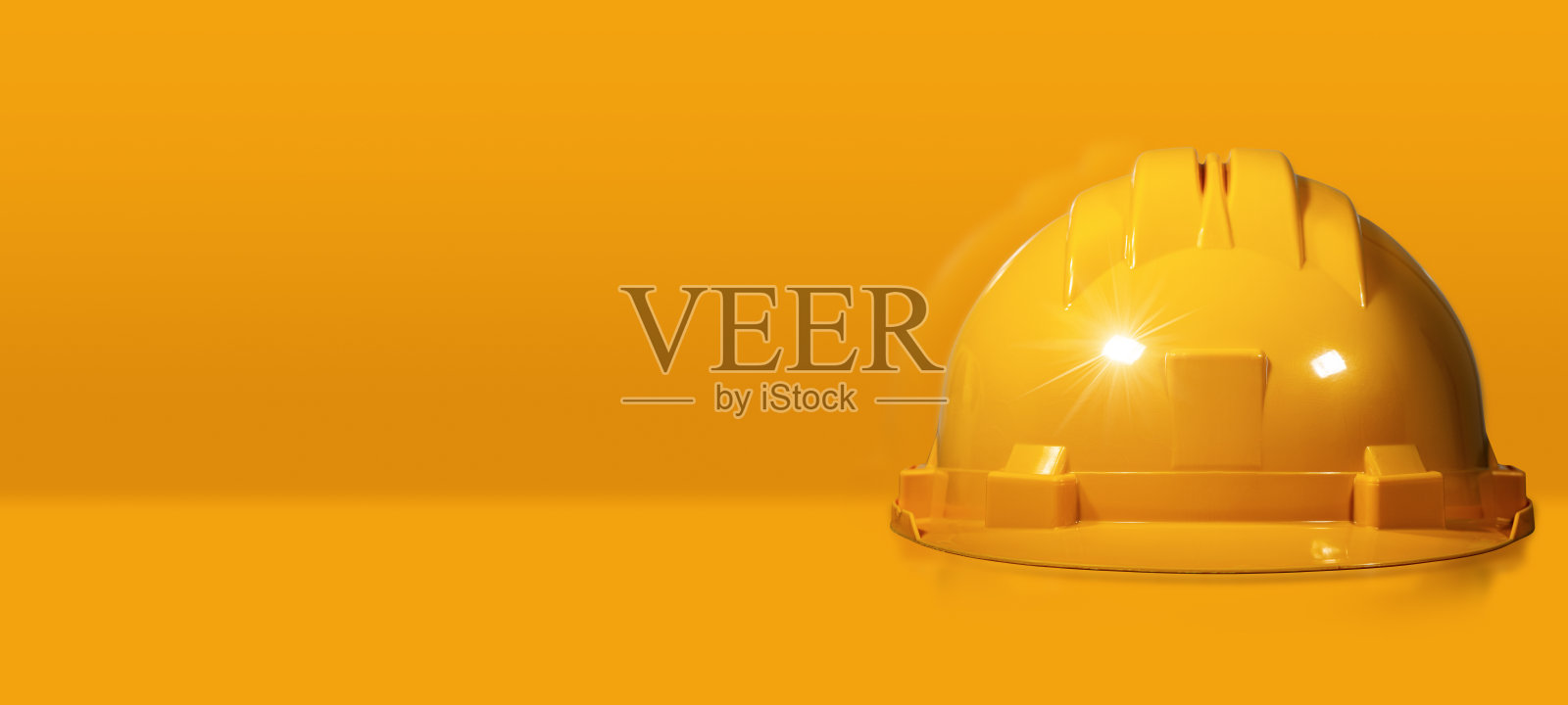 黄色背景上的橙色安全帽或安全帽照片摄影图片