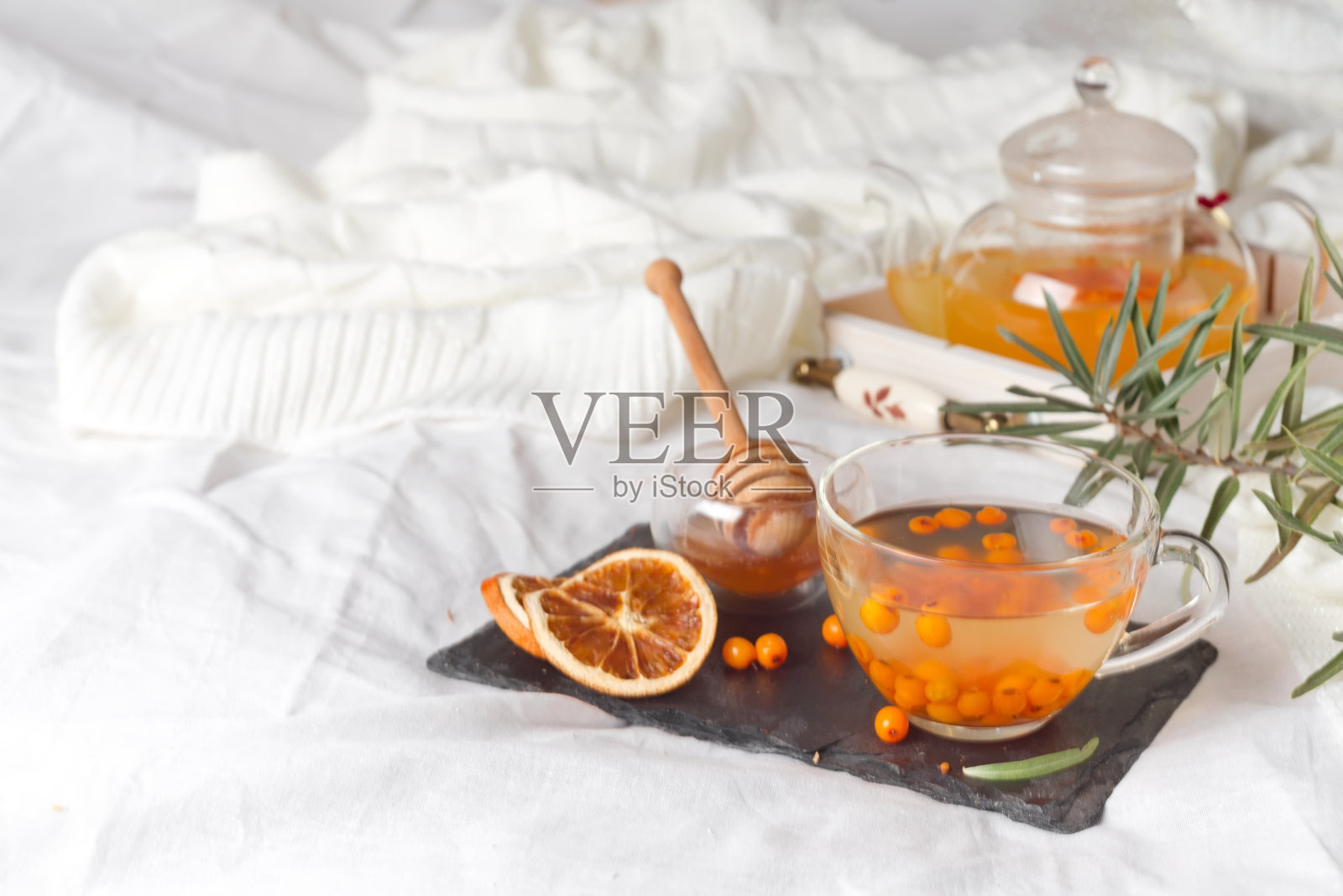 床上放有姜、柠檬、蜂蜜和沙棘的秋季热茶照片摄影图片