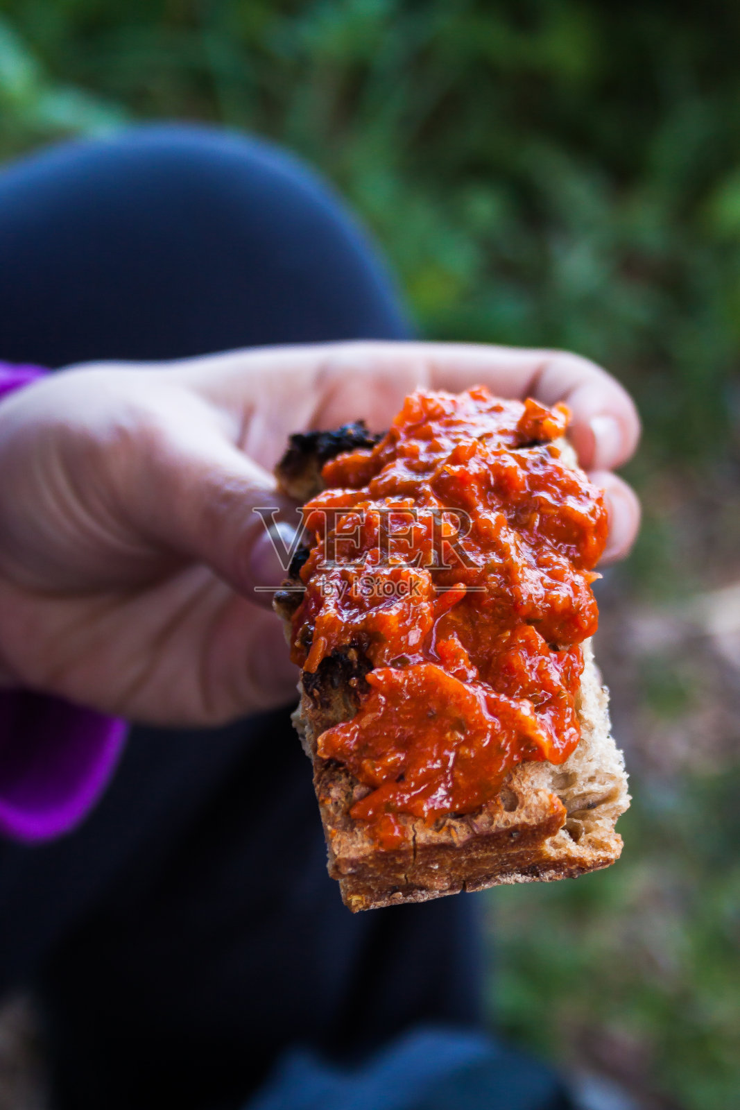 一名女徒步旅行者在户外准备一份蔬菜三明治照片摄影图片