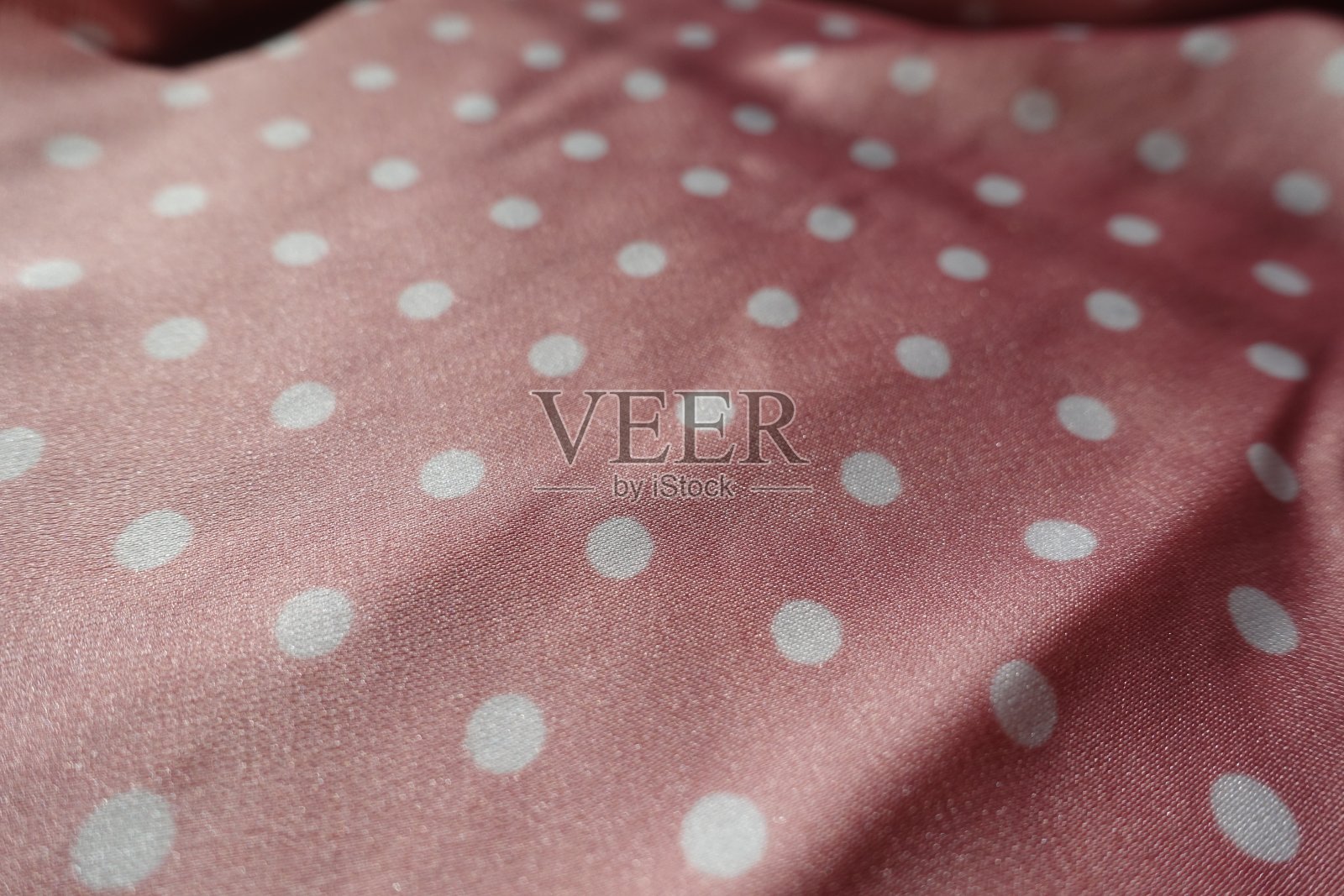粉红和白色缎面聚酯织物与波尔卡点图案的特写照片摄影图片