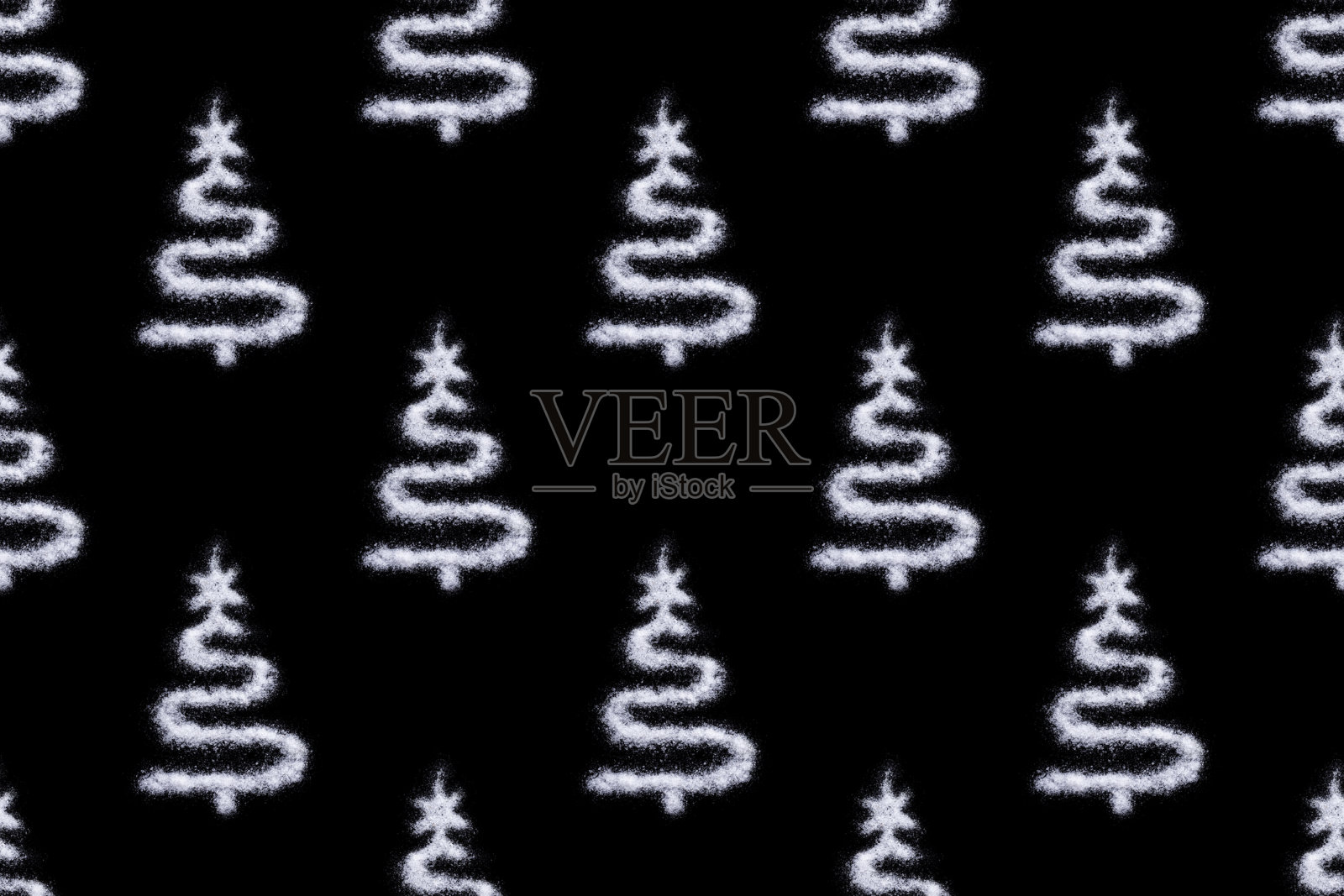 在黑色的背景上画上盐状雪的创意圣诞树。最小的假日概念照片摄影图片