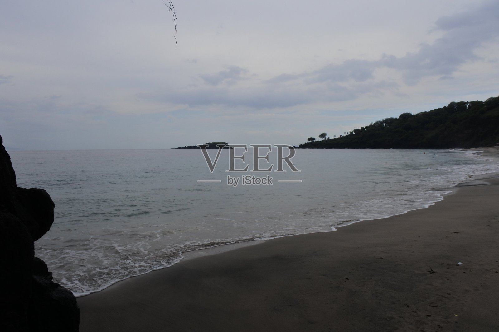 巴厘岛的Karangasem处女海滩。沿海植被。海浪和开阔的海洋以美丽的全景品味一个热带岛屿照片摄影图片