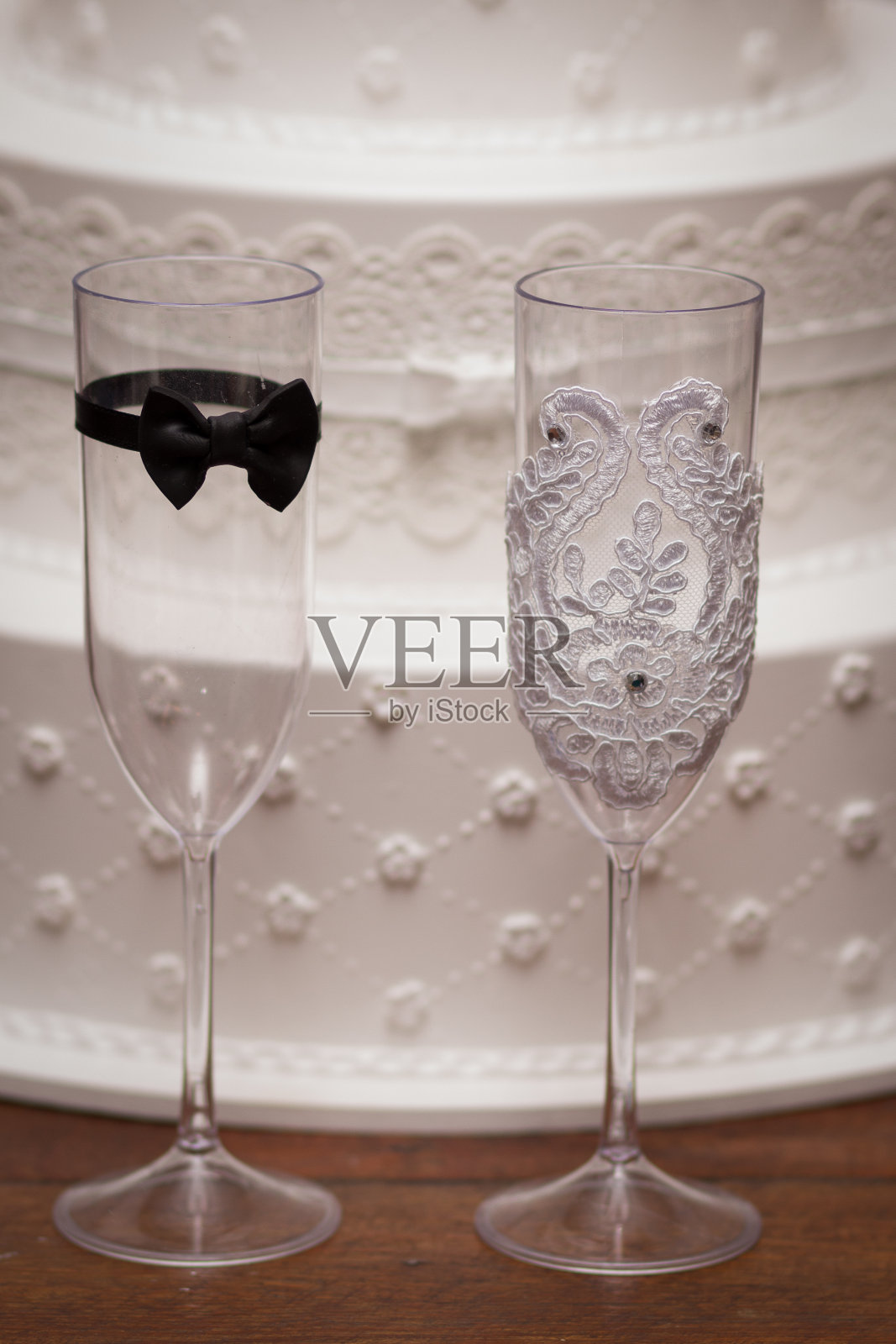 新娘和新郎的杯子,背景是蛋糕照片摄影图片