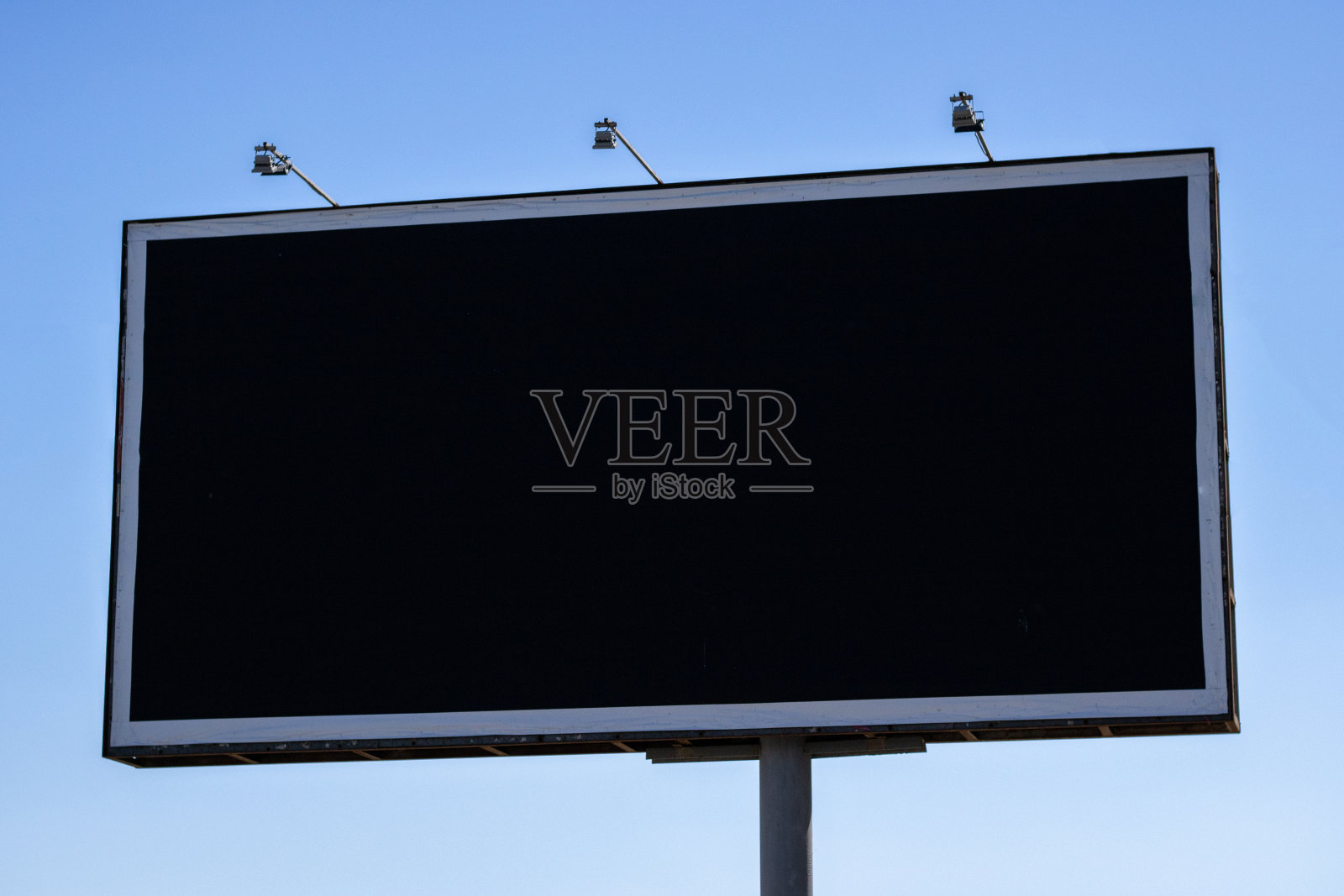 大型户外城市黑色空广告牌在蓝天上。照片摄影图片