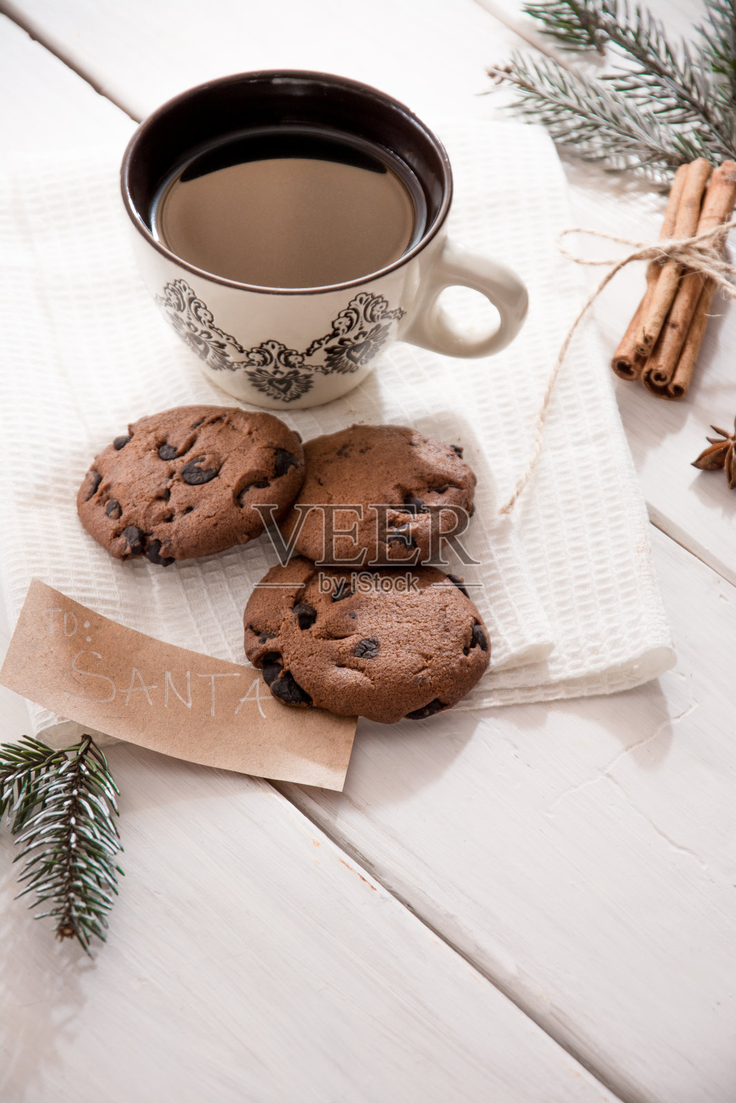 饼干圣诞老人和咖啡杯木制背景与冷杉枝和肉桂,概念圣诞假期的传统。副本的空间。照片摄影图片