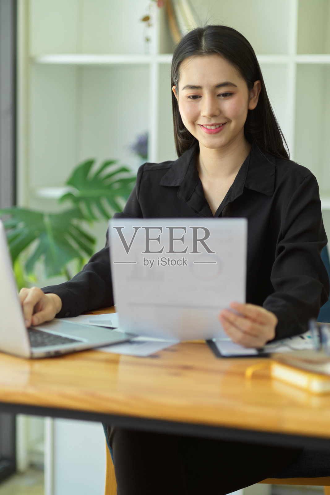 商界女性看着财务报告并对结果感到满意。照片摄影图片