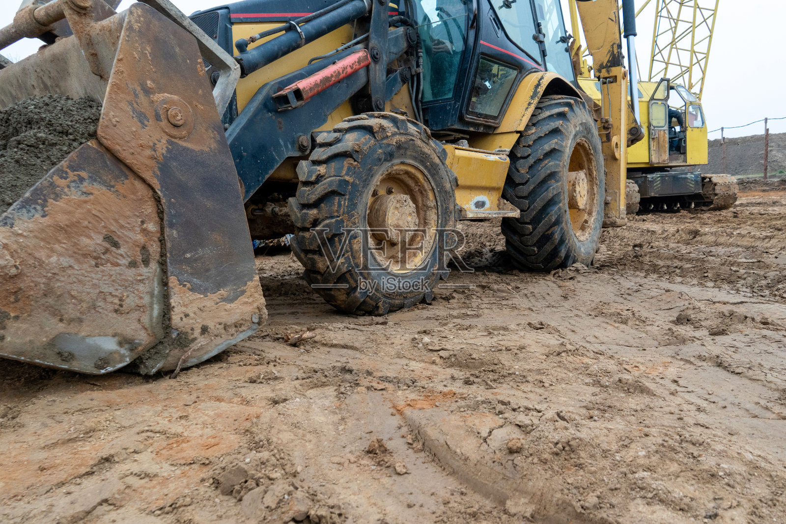 一辆黄色挖掘机在街道上的建筑工地照片摄影图片