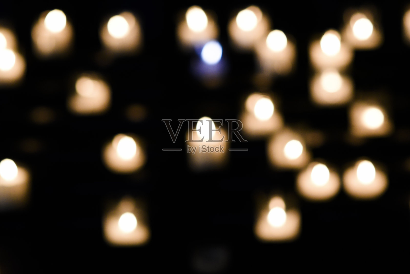 教堂里点燃祈祷用的毛茸茸的蜡烛。照片摄影图片