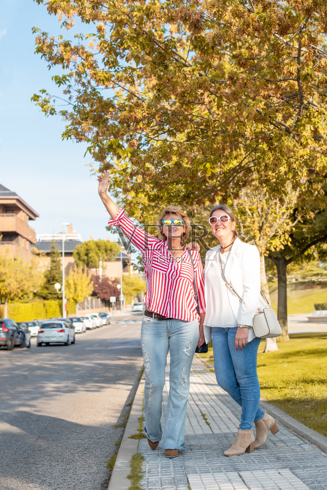 两个中年白人妇女在街上叫出租车照片摄影图片