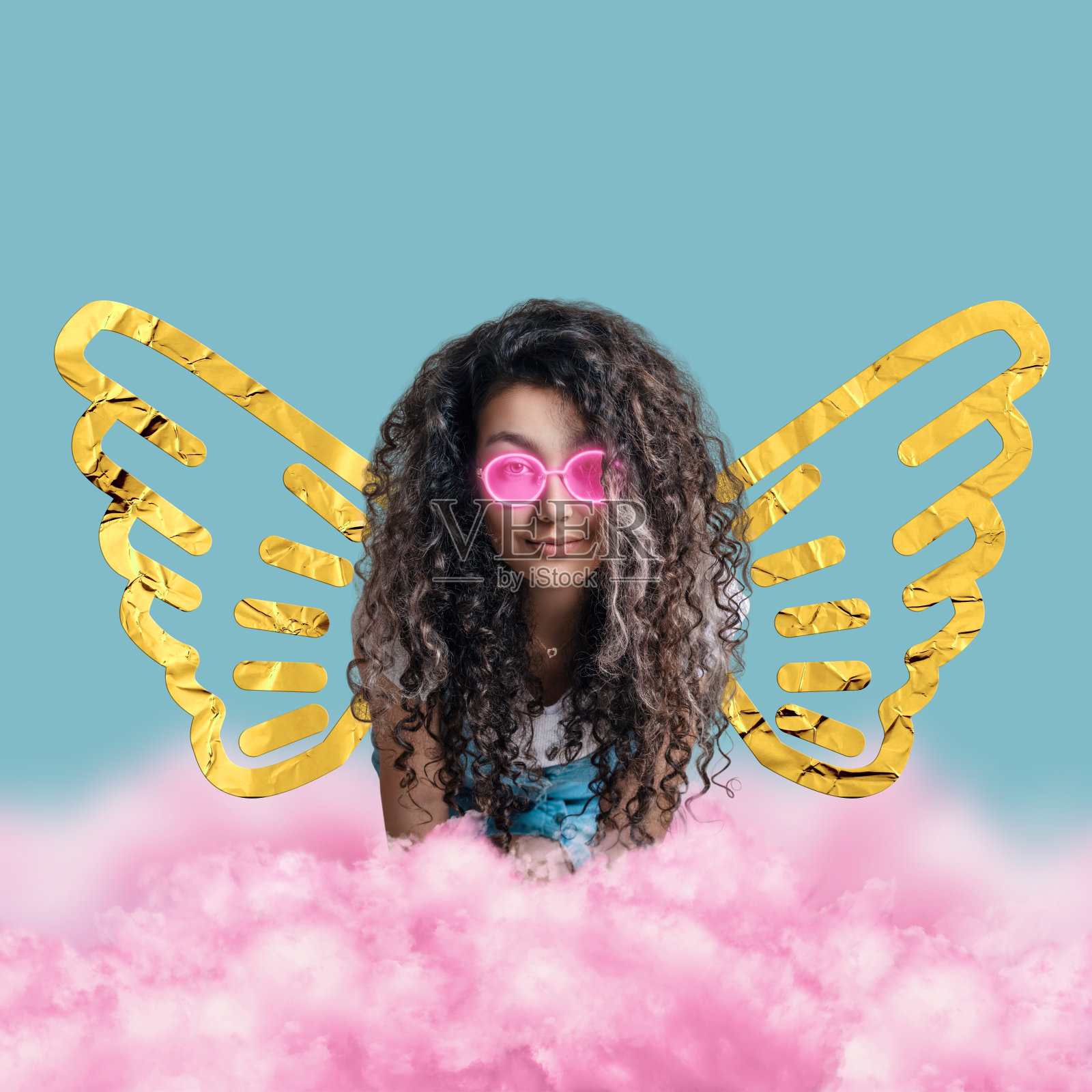 一个女孩带着箔天使翅膀和发光的霓虹灯眼镜被粉红色的云包围。照片摄影图片